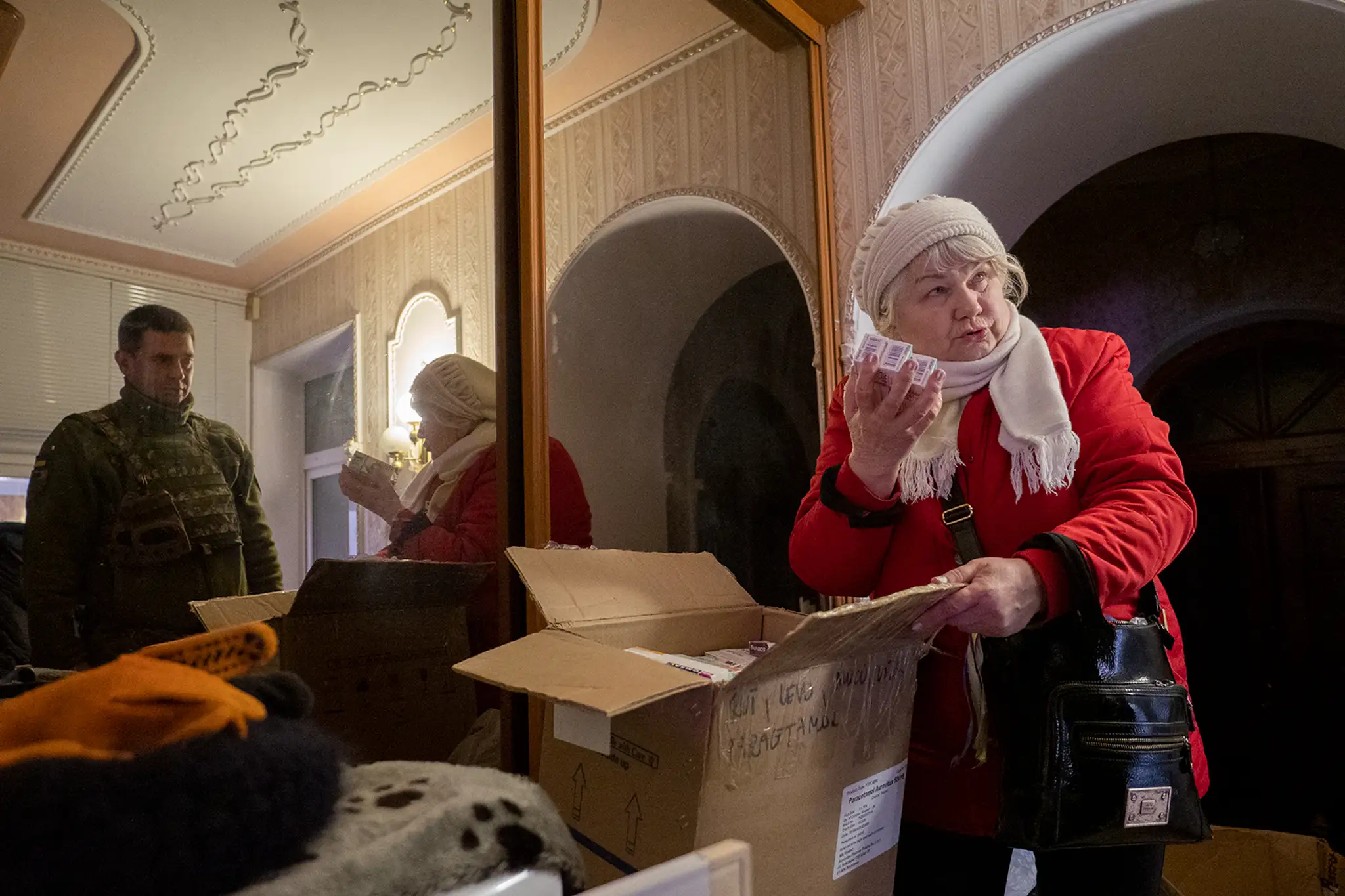 Galina Ivanovna odovzdáva Ivanovi materiál vyzberaný od dobrovoľníkov