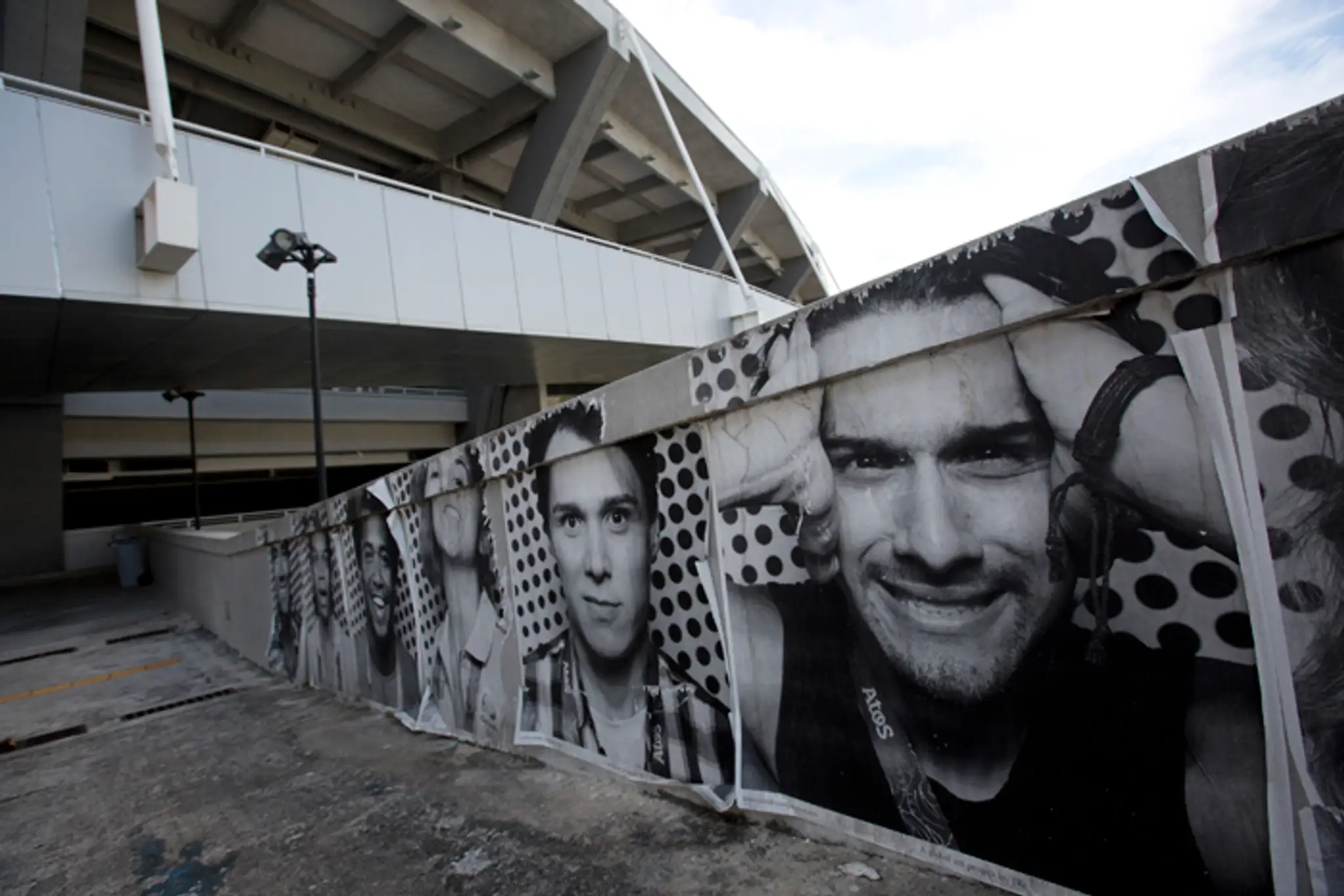 Fotografie olympijských dobrovoľníkov visia v okolí futbalového štadióna Maracana.