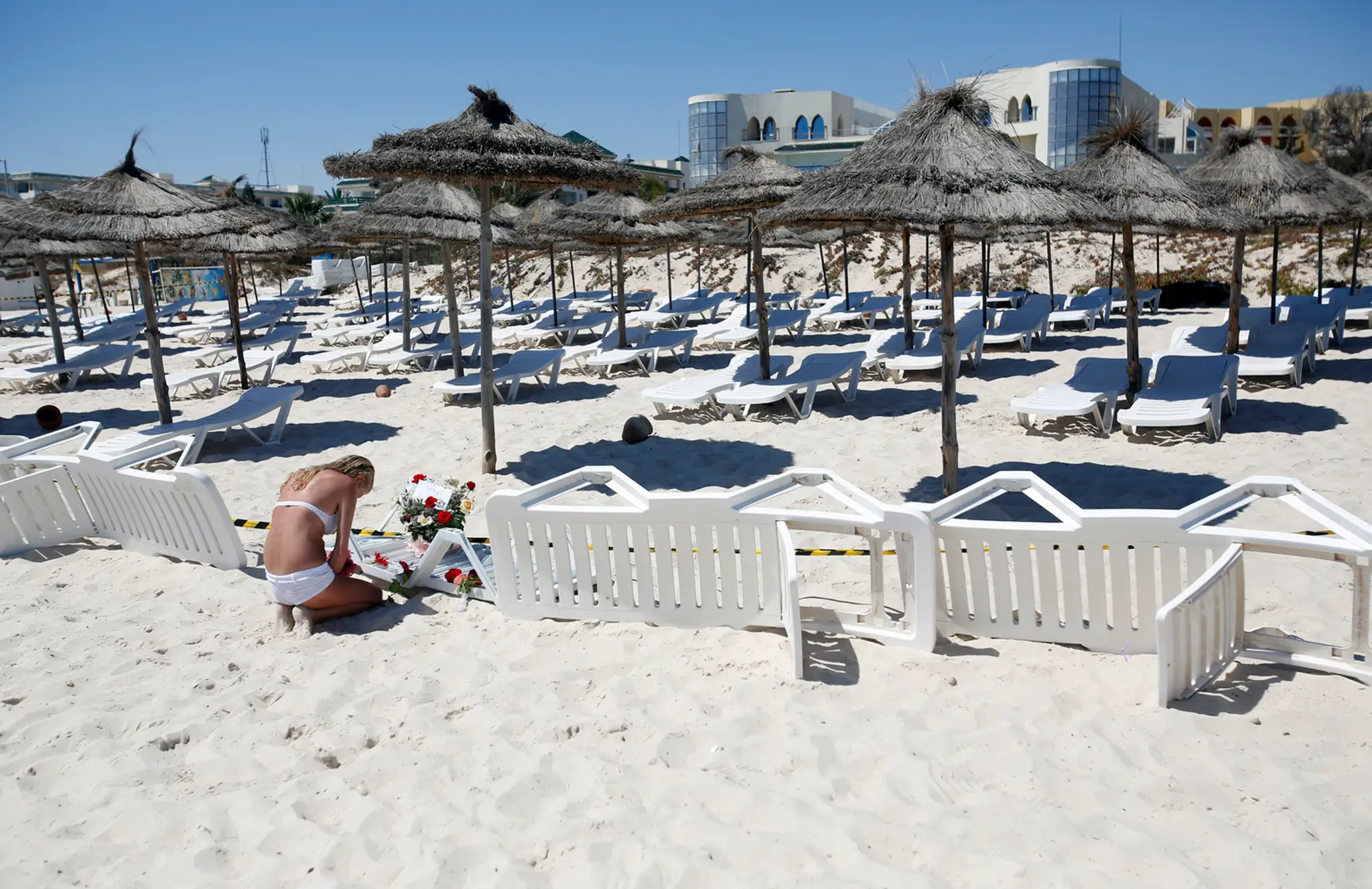 Mladá žena kladie kvety na pláž hotela Imperial Marhaba. 27. jún
