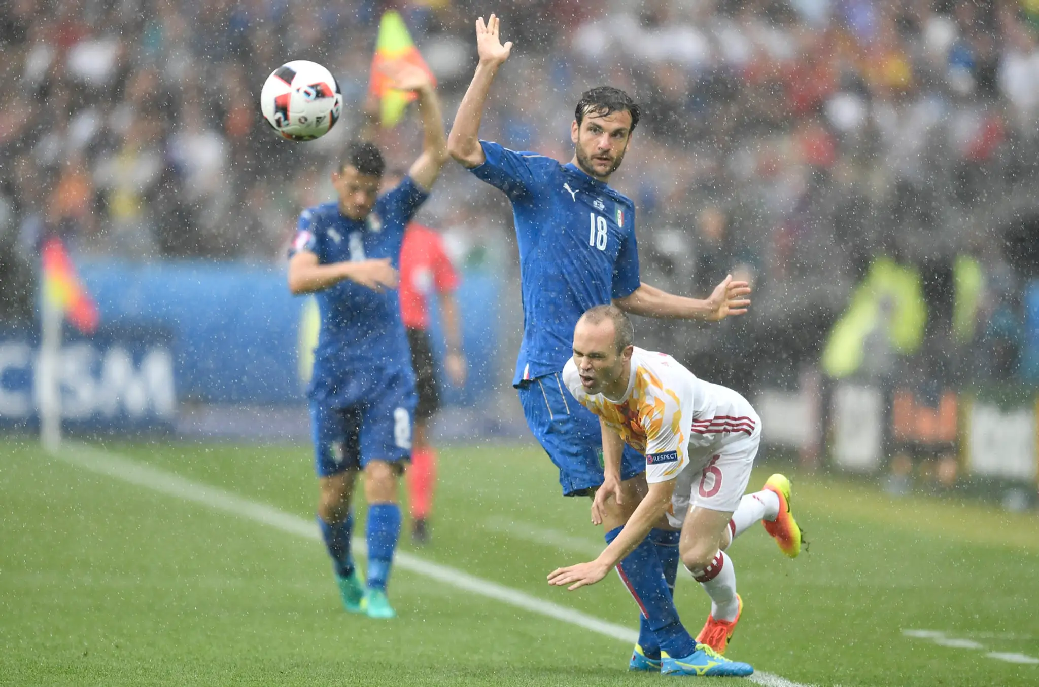 Talian Marco Parolo (uprostred) a Španiel Andrés Iniesta bojujú o loptu v osemfinále ME.