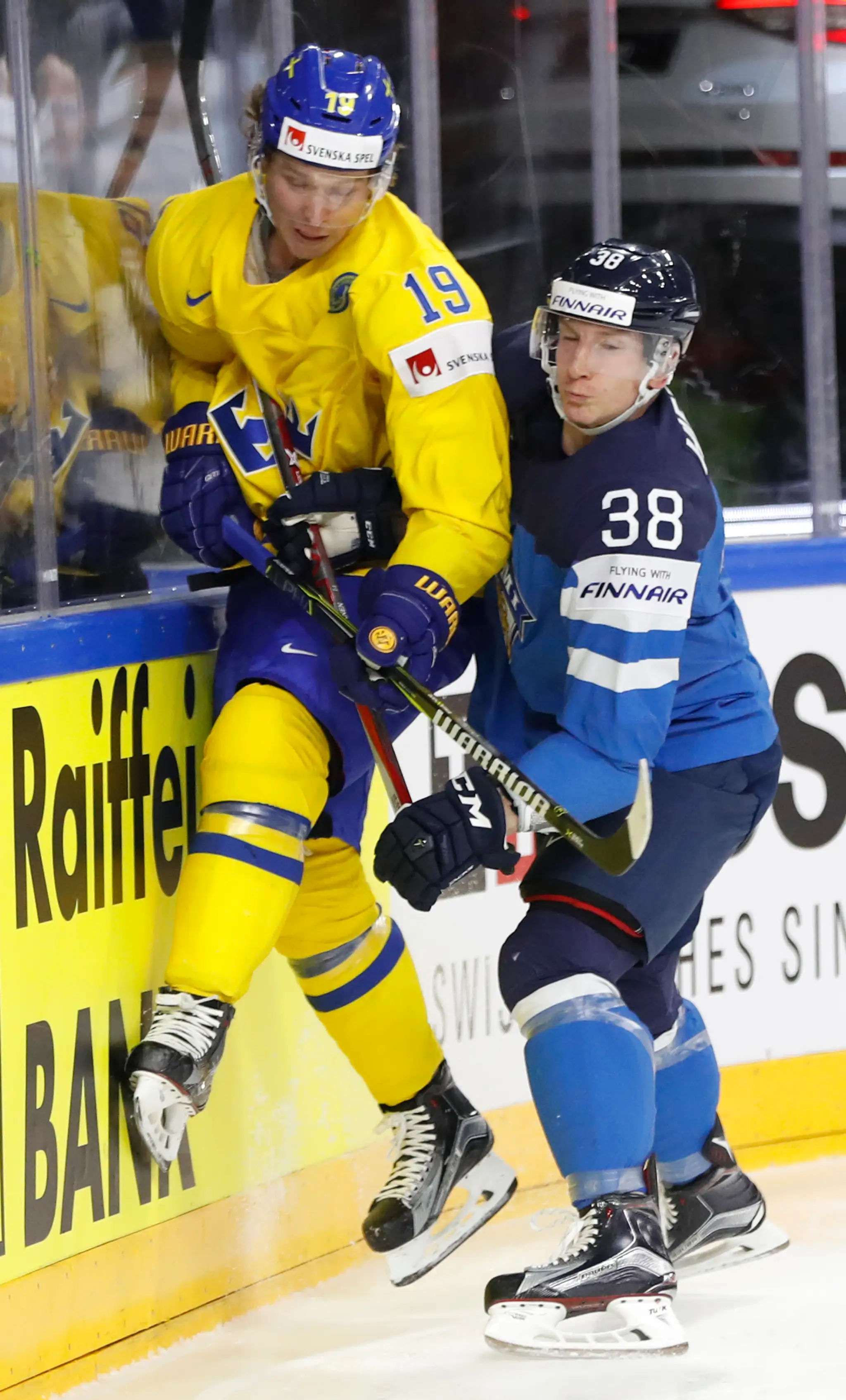 Švéd Nicklas Bäckström (vľavo) a Fín Juuso Hietanen bojujú o puk v semifinále MS 2017.