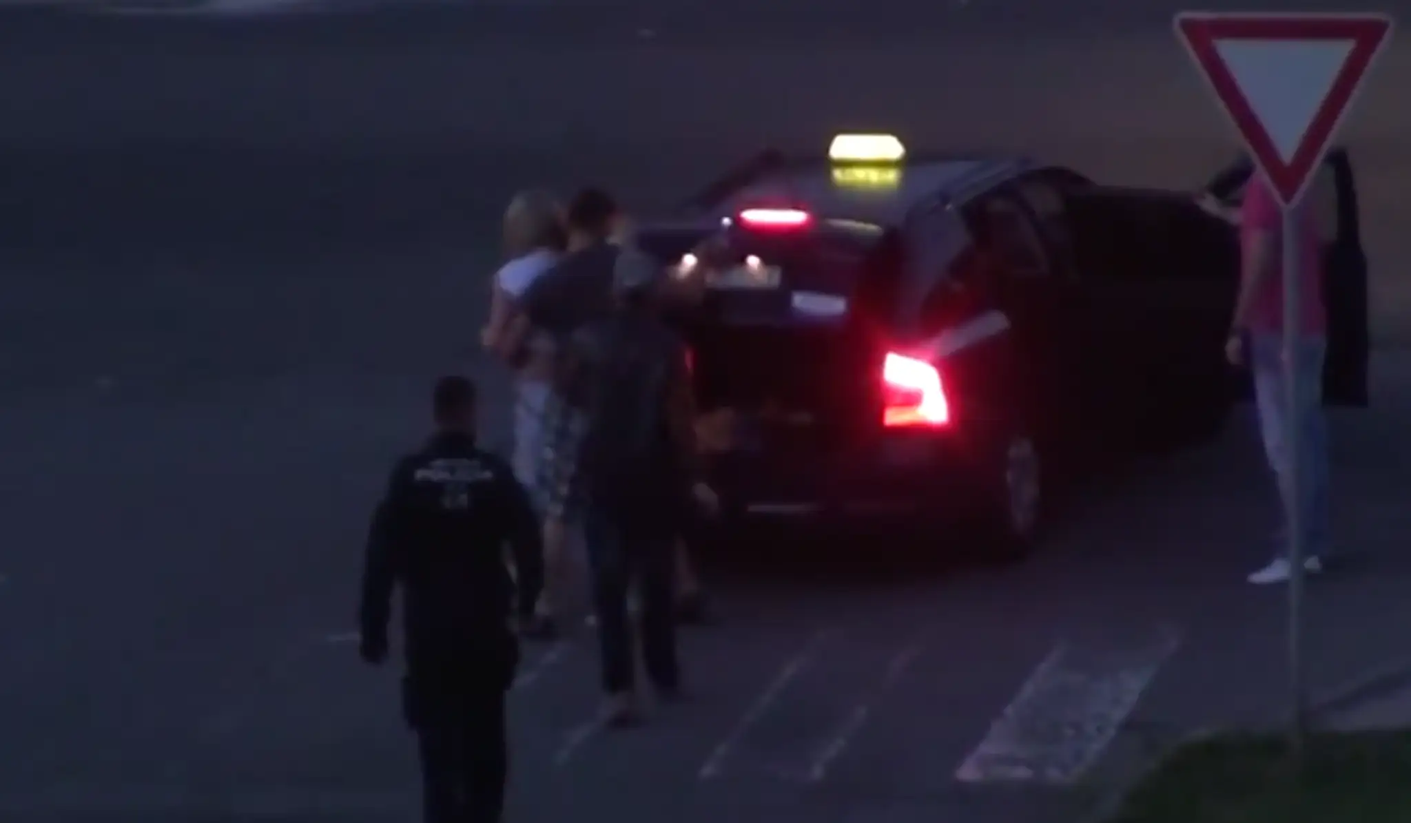 Mestský policajt sa prizerá ako dievča nakladajú do kufra