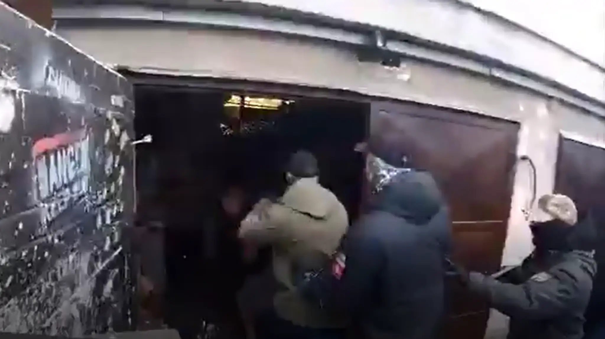 Na snímke sú muži, ktorí vchádzajú do garáže.