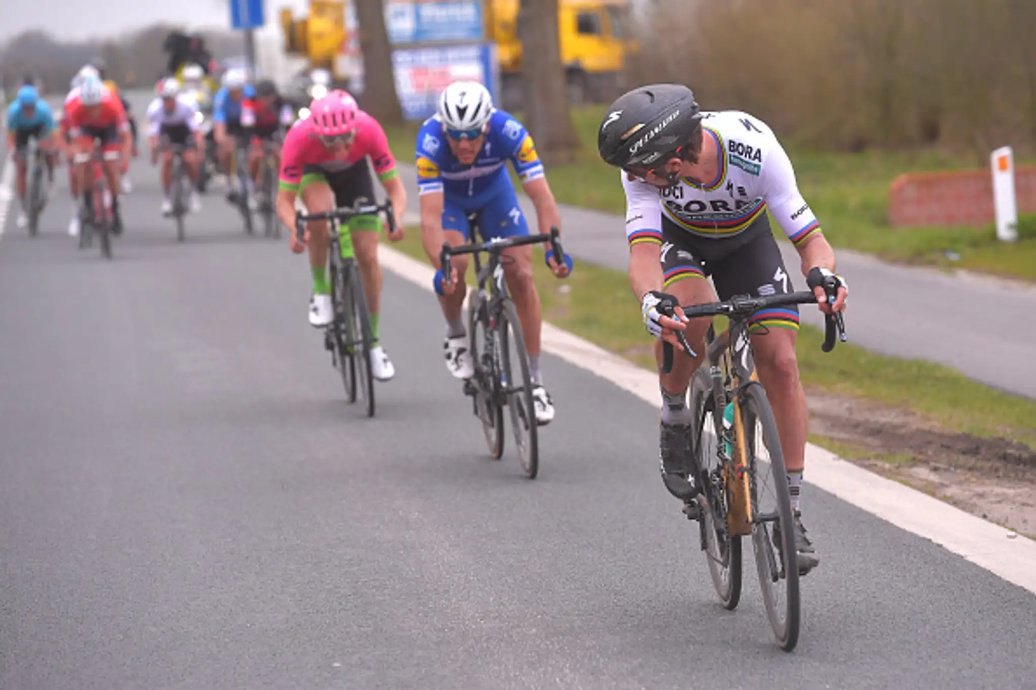 Peter Sagan sa cez rameno vyčítavo pozerá na jazdcov za ním.