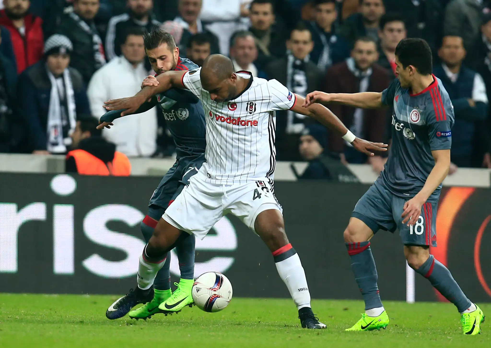 Ryan Babel z Besiktasu si stráži loptu pred hráčmi Olympiacosu v odvete osemfinále EL.