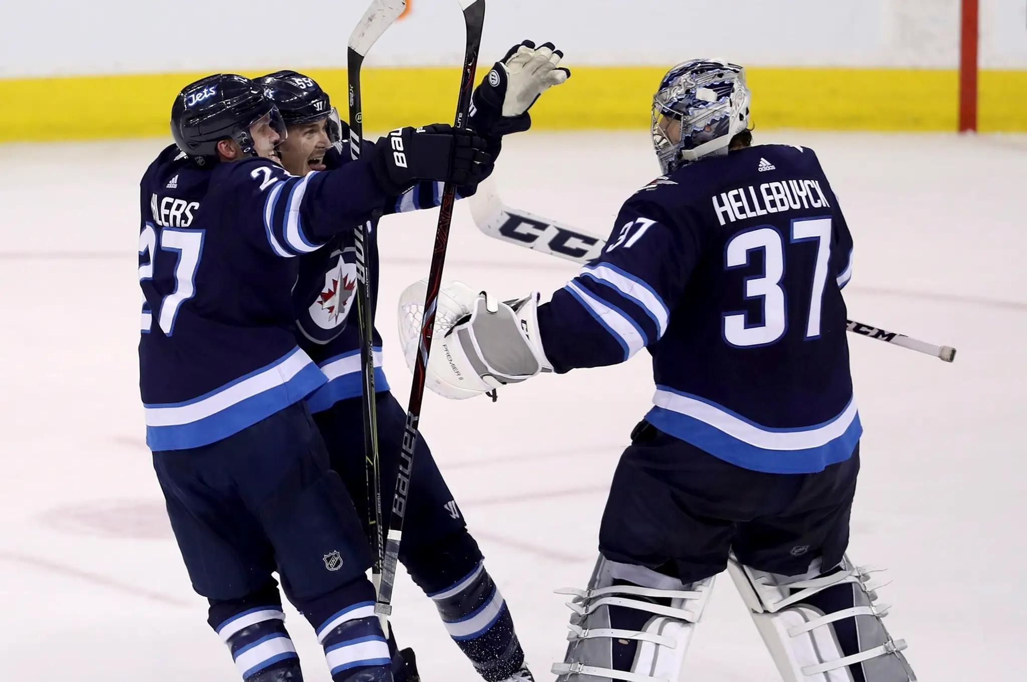 Hokejisti Winnipegu Jets Nikolaj Ehlers (vľavo), Mark Scheifele (uprostred) a brankár Connor Hellebuyck (vpravo)