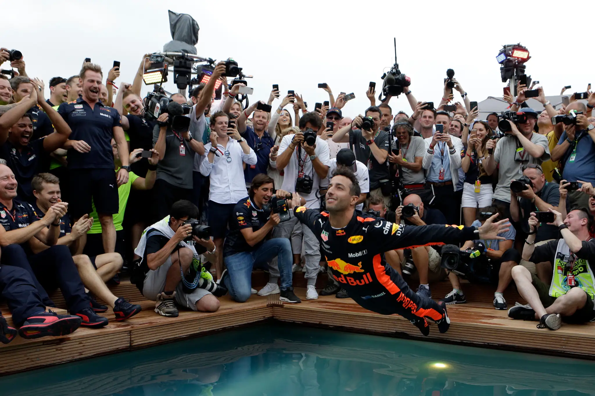 Pilot F1 Daniel Ricciardo skáče do bazéna po triumfe vo VC Monaka.