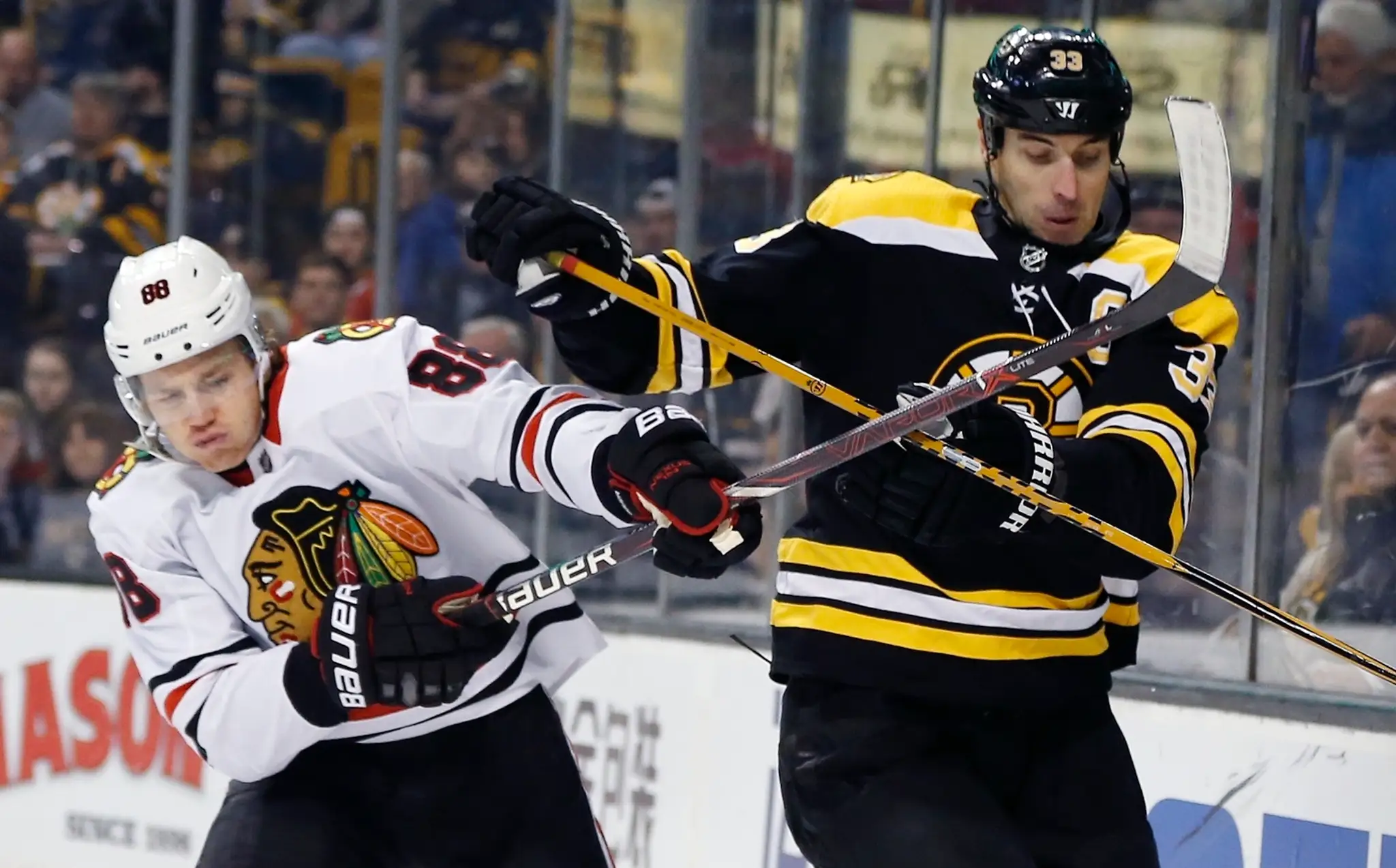 Patrick Kane (Chicago) a Zdeno Chára (Boston) v súboji o puk.