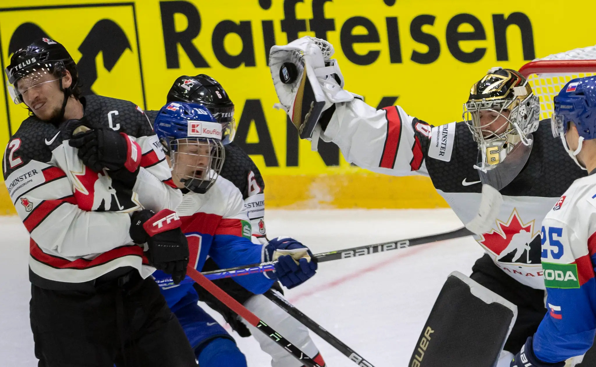 Uprostred Adam Sýkora, vľavo Thomas Chabot a brankár Logan Thompson (obaja Kanada) v zápase MS 2022.