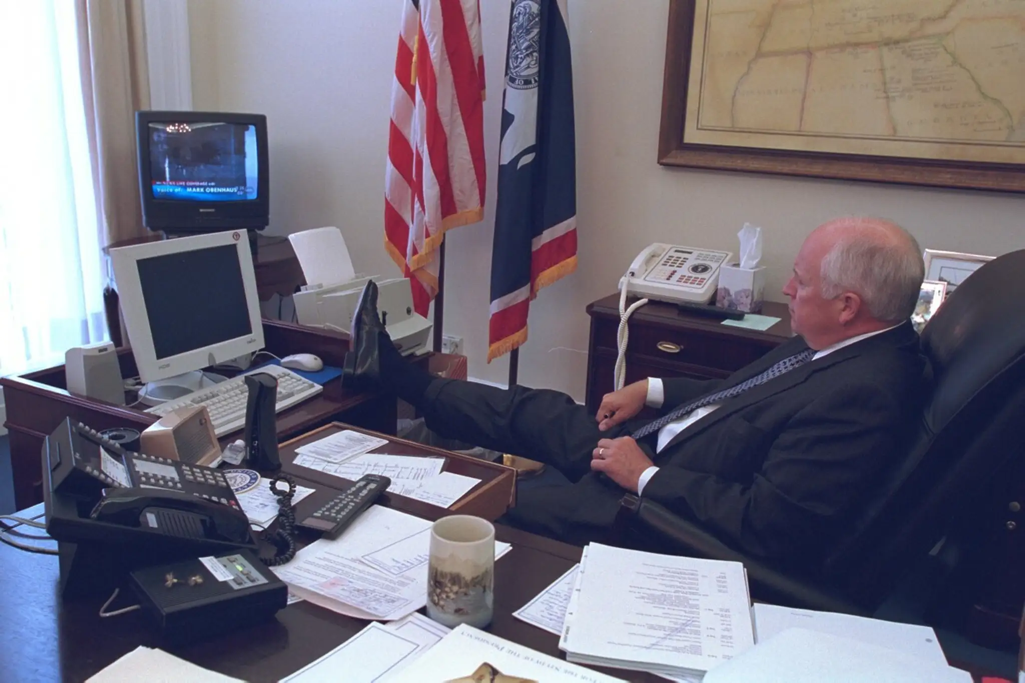 Viceprezident Dick Cheney s nohou na stole sleduje správy o útokoch na Ameriku
