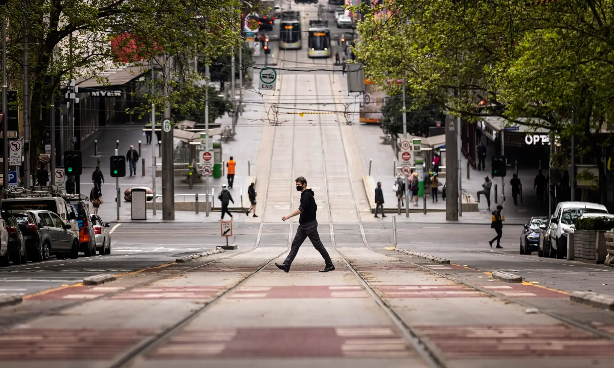 Na archívnej snímke z 30. septembra 2021 ľudia kráčajú cez cestu v Melbourne.