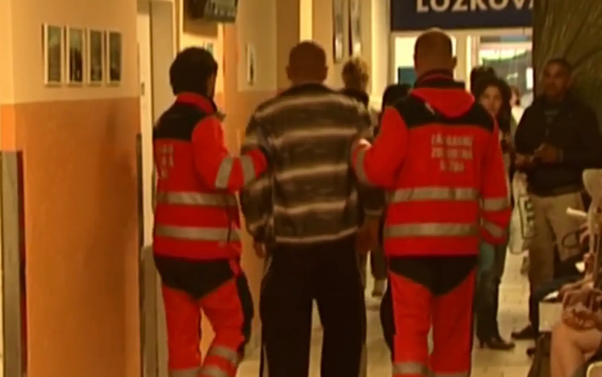 Záchranári odvádzajú opilca na ošetrenie 
