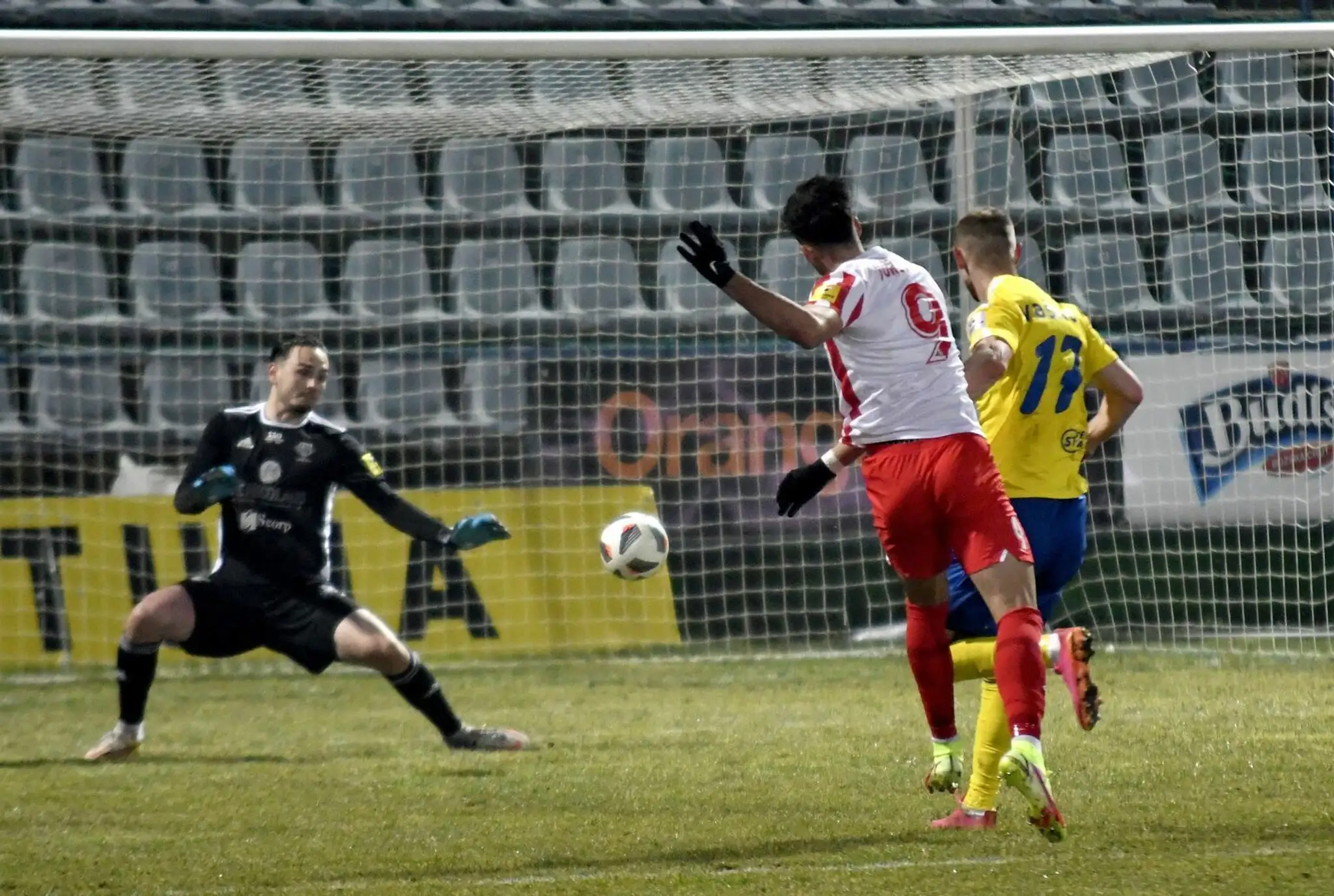 Na snímke uprostred hráč ŠKF Sereď Roko Jureškin strieľa gól brankárovi MFK Zemplín Michalovce Andrijovi Kožucharovi.