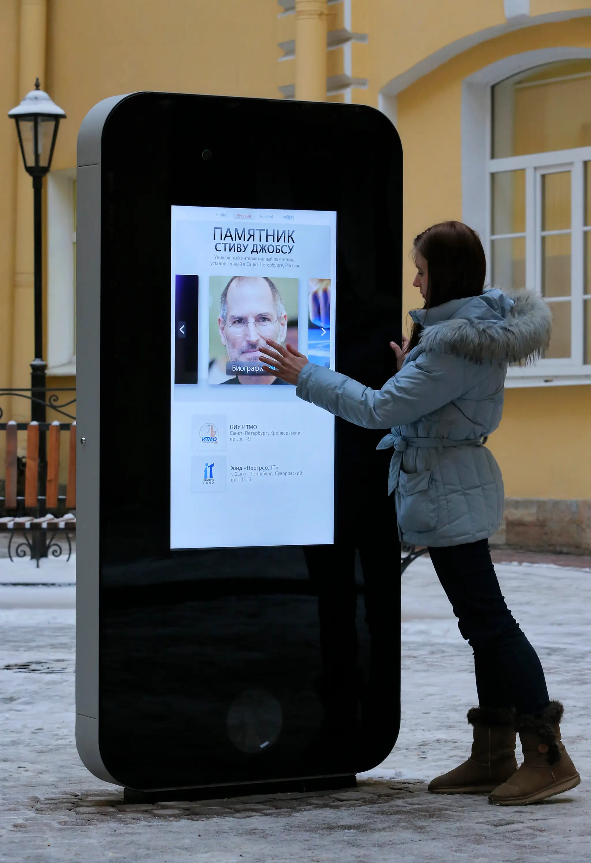 Dievča sa dotýka sochy ikonického smartfónu