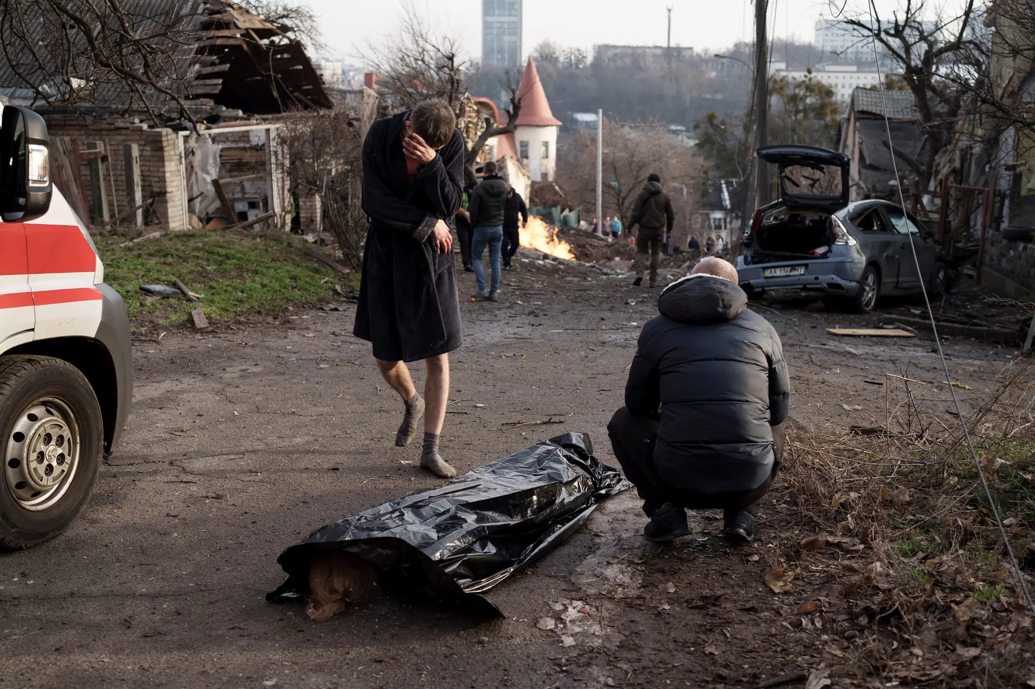 Na archívnej snímke jedna z ukrajinských obetí ruského bombardovania. Muž plače nad telom manželky.