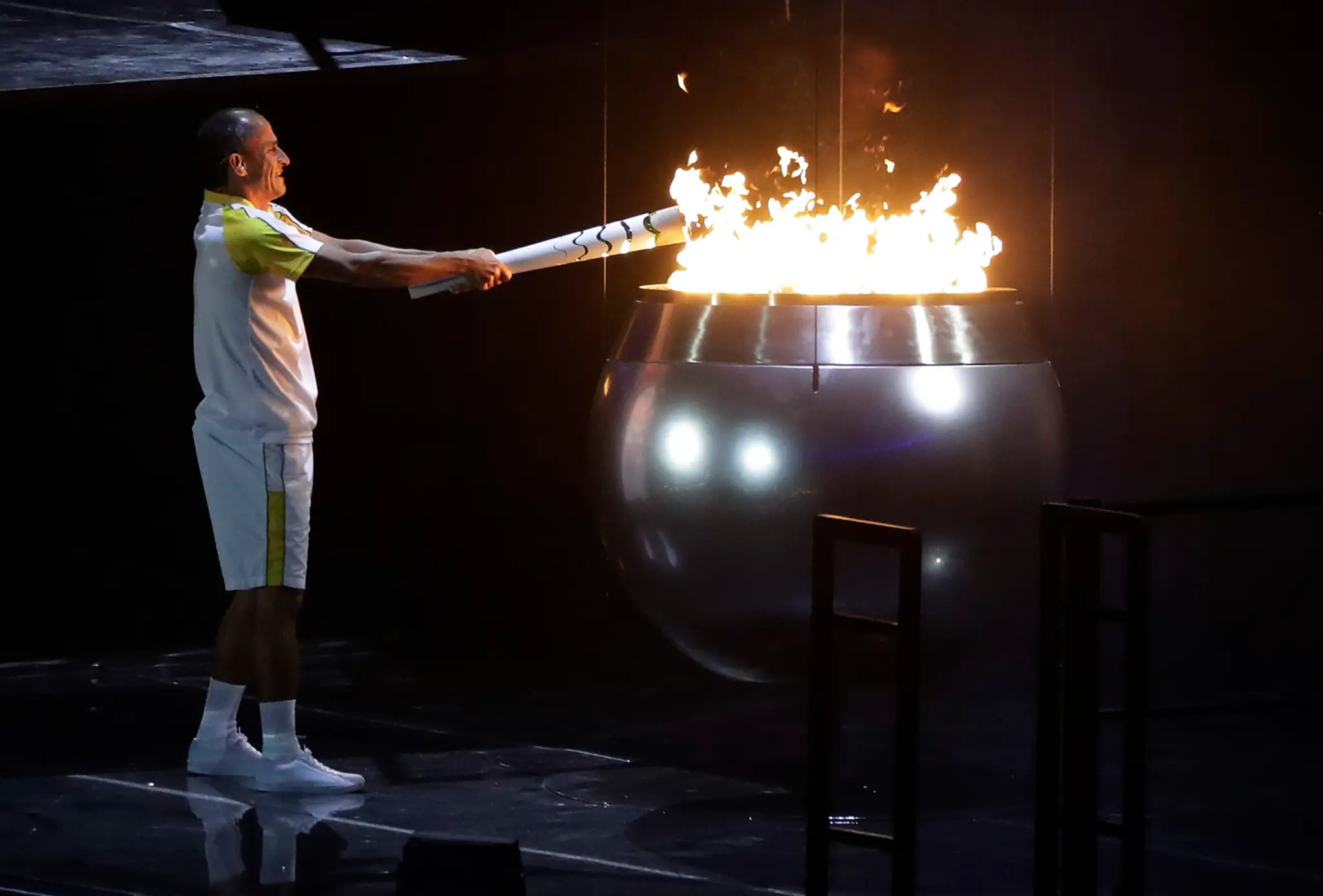 Brazílsky bežec Vanderlei de Lima zapaľuje olympijský oheň na štadióne Maracana počas otváracieho ceremoniálu OH v Riu.