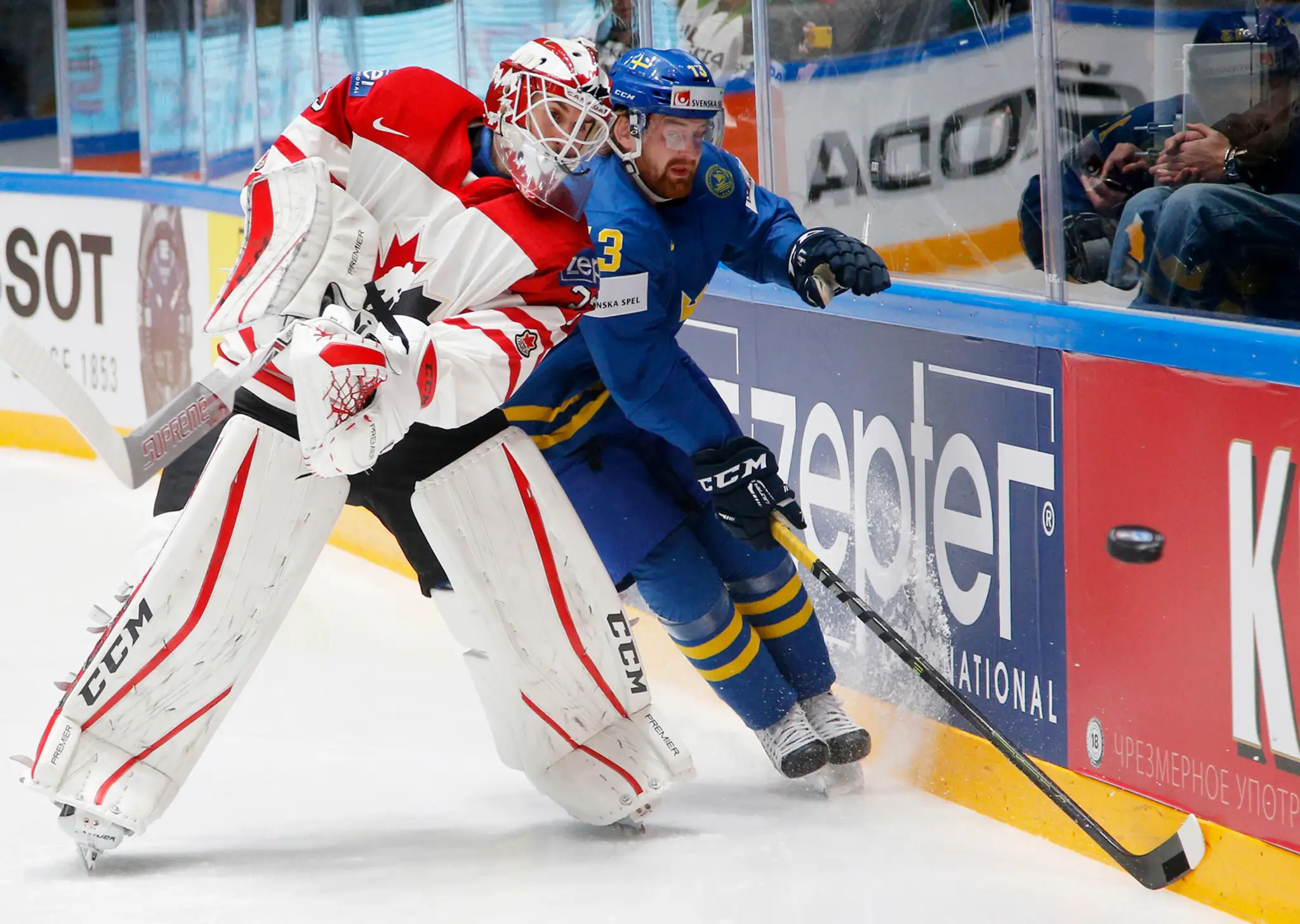 Švéd Mattias Ritola (vpravo) a kanadský brankár Cam Talbot bojujú o puk pri mantineli vo štvrťfinále MS v Rusku.