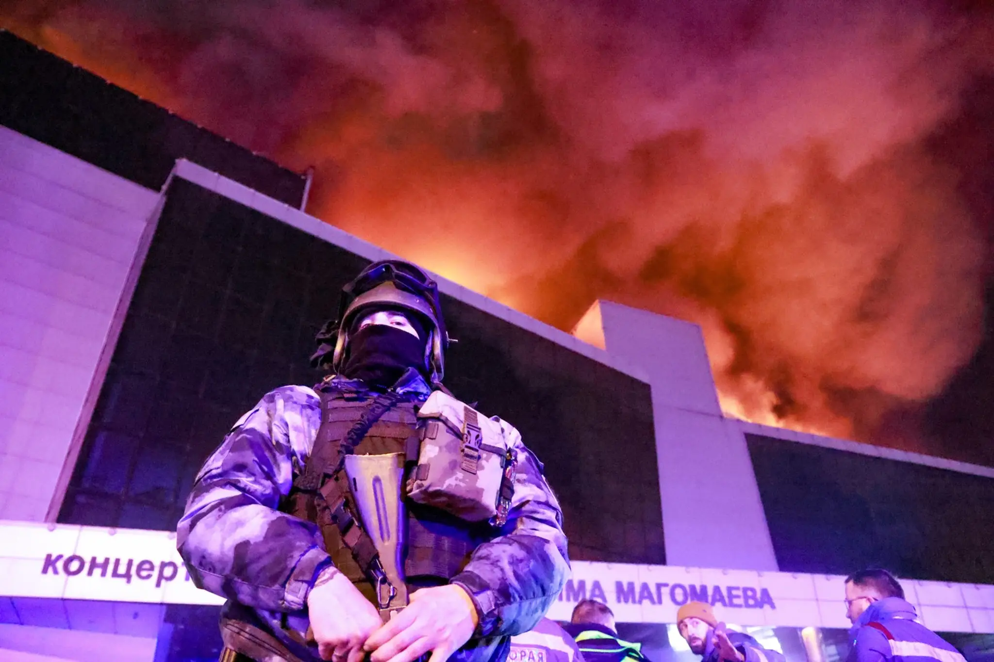 Policajt stráži horiacu budovu v Moskve.