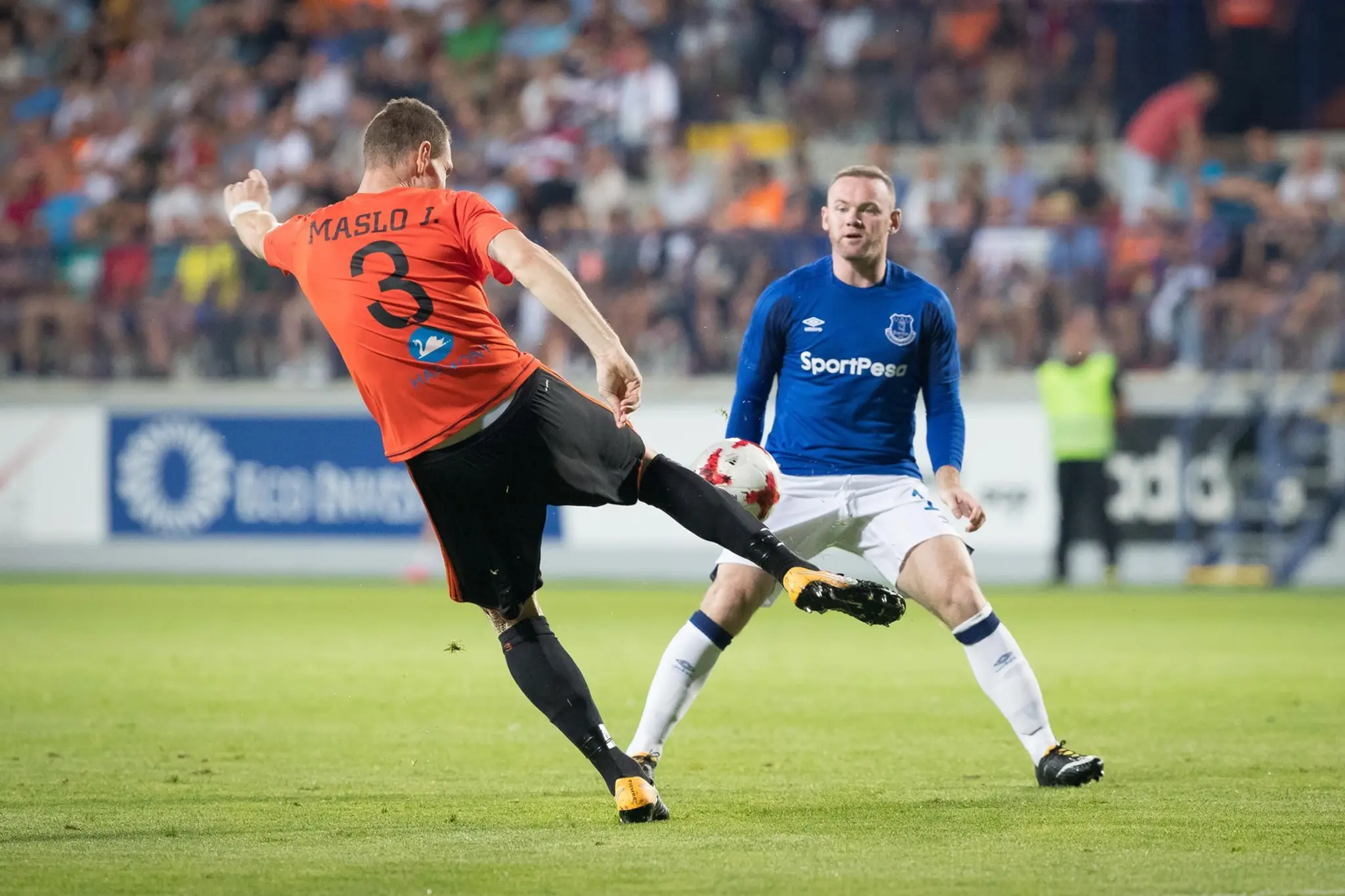 Ružomberčan Ján Maslo bojuje o loptu s Wayneom Rooneym z Evertonu (vpravo) v odvete 3. predkola EL.