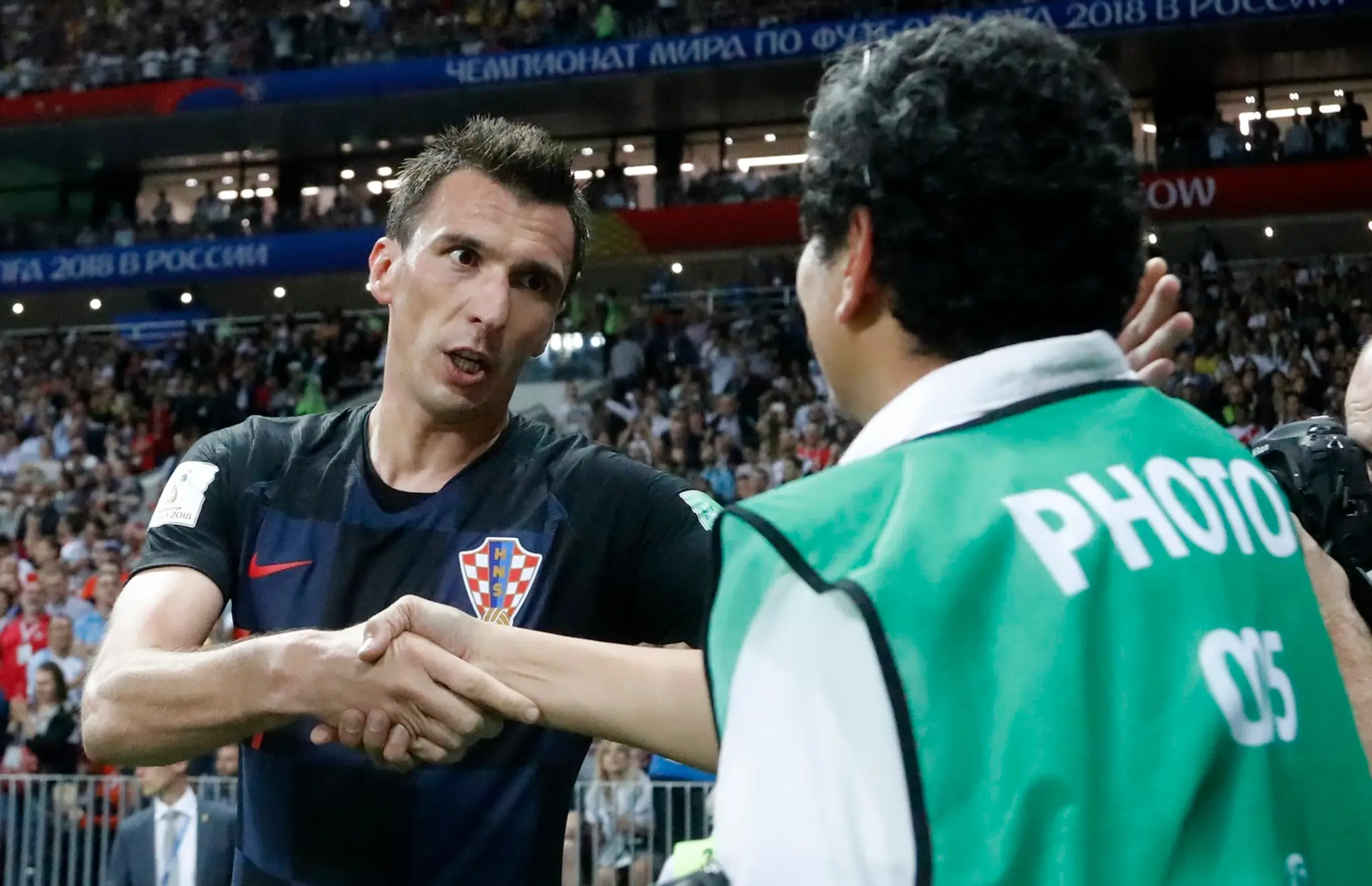 Mario Mandžukič sa ospravedlňuje fotografovi, na ktorého spadol po strelení víťazného gólu proti Anglicku.