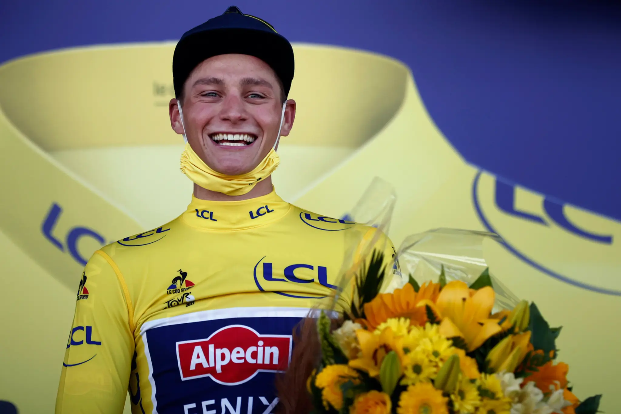 Holandský cyklista Mathieu van der Poel sa teší na pódiu v žltom drese.