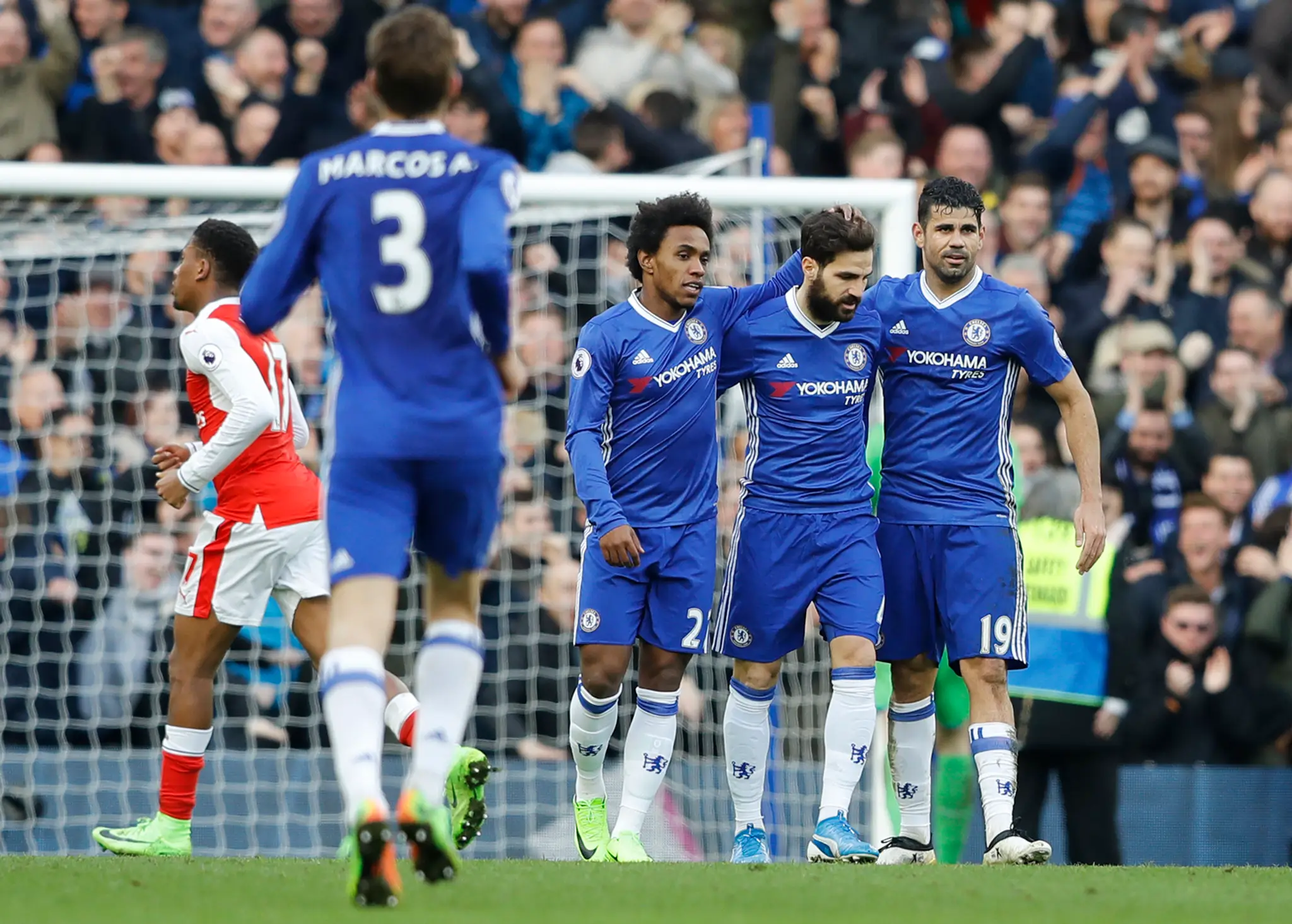Willian a Diego Costa gratulujú Fabregasovi ku gólu do siete Arsenalu.