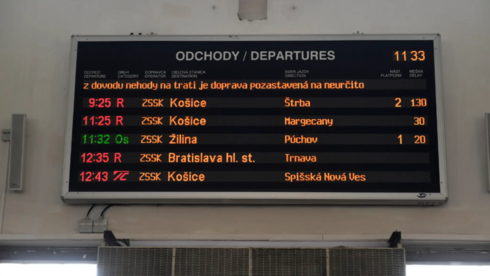 Informačná tabuľa o meškaní vlakov na železničnej stanici v Trenčíne.
