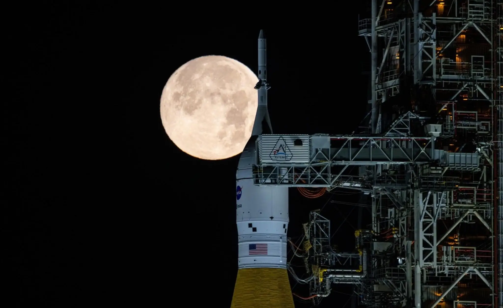 V skorých ranných hodinách 1. februára svieti spln nad raketou SLS (Space Launch System) a kozmickou loďou Orion NASA.