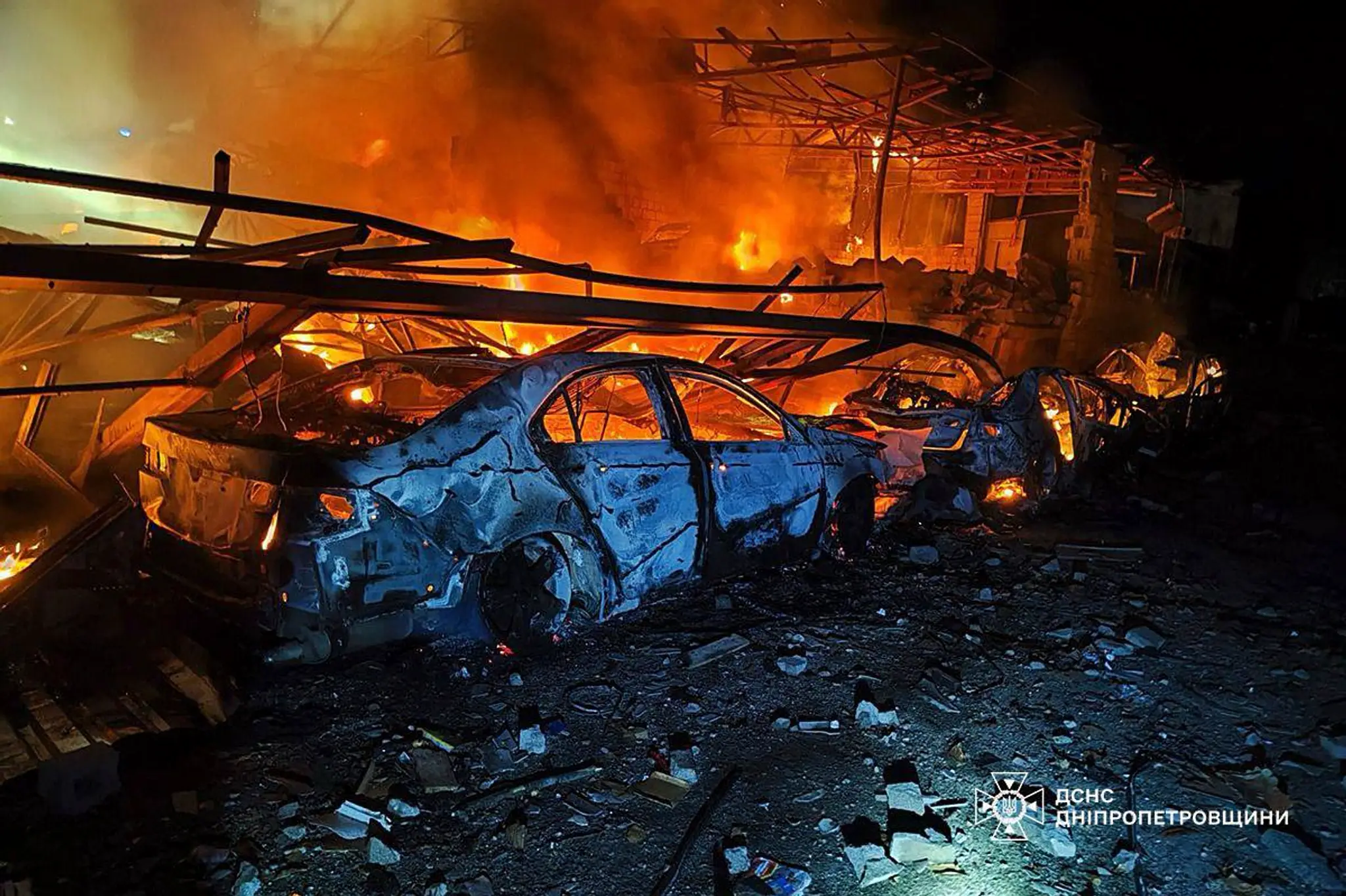 Príslušníci záchranných zložiek hasia požiar po leteckom útoku ruskej armády na ukrajinské mesto Kamjanske.