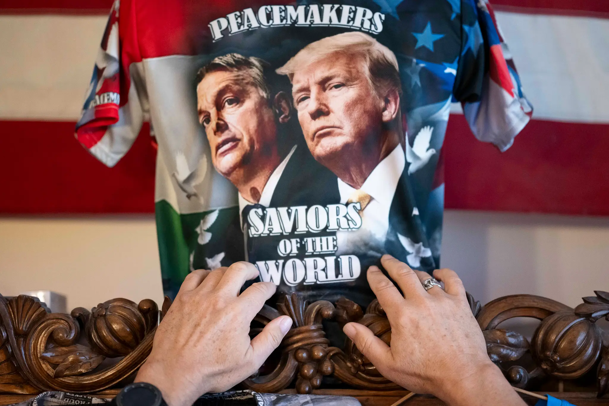 Akos Szilagyi, jeden z najvýznamnejších stúpencov Viktora Orbána, si upravuje jedno zo svojich vlastnoručne navrhnutých tričiek, na ktorom je vyobrazený Orbán a americký prezident Donald TrumpAkos Szilagyi, jeden z najvýznamnejších stúpencov Viktora Orbán