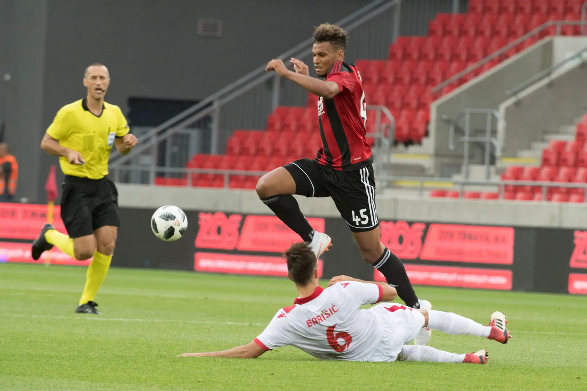 Na snímke na tráve Hrvoje Baršič (Zrinjski) a nad ním Marvin Egho (Trnava) počas stretnutia 1. predkola Ligy majstrov Spartak Tr