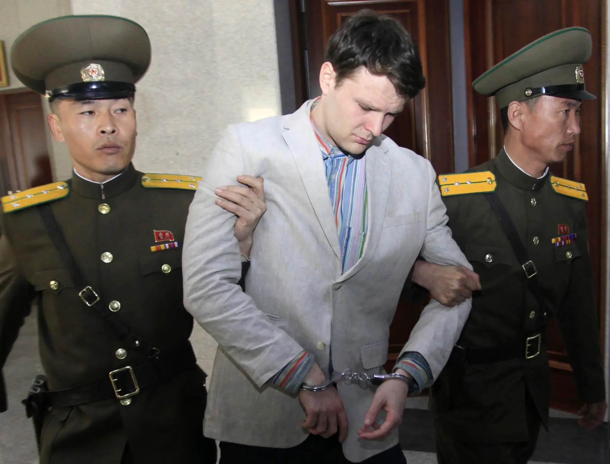 Otto Warmbier prichádza na súd v Pchjongjangu. 