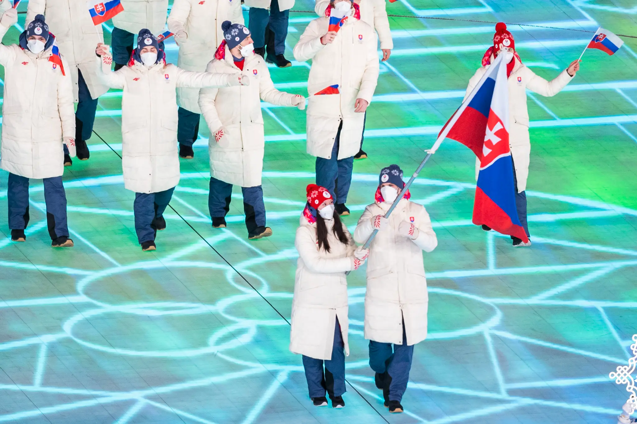 Vlajkonosiči slovenskej výpravy - hokejista Marek Hrivík a sánkarka Katarína Šimoňáková počas otváracieho ceremoniálu ZOH 2022.