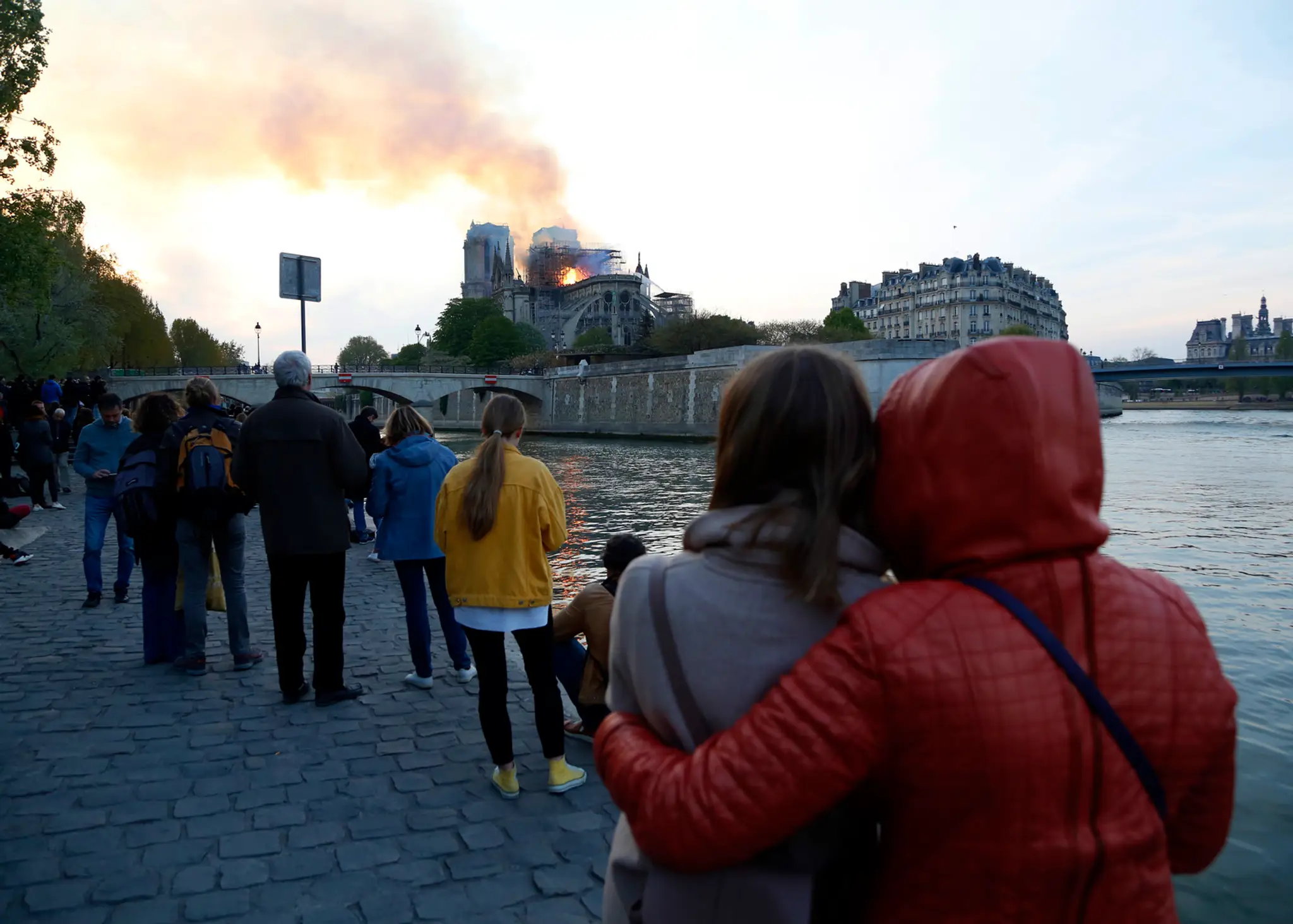 Ľudia sledujú hasenie katedrály Notre Dame.