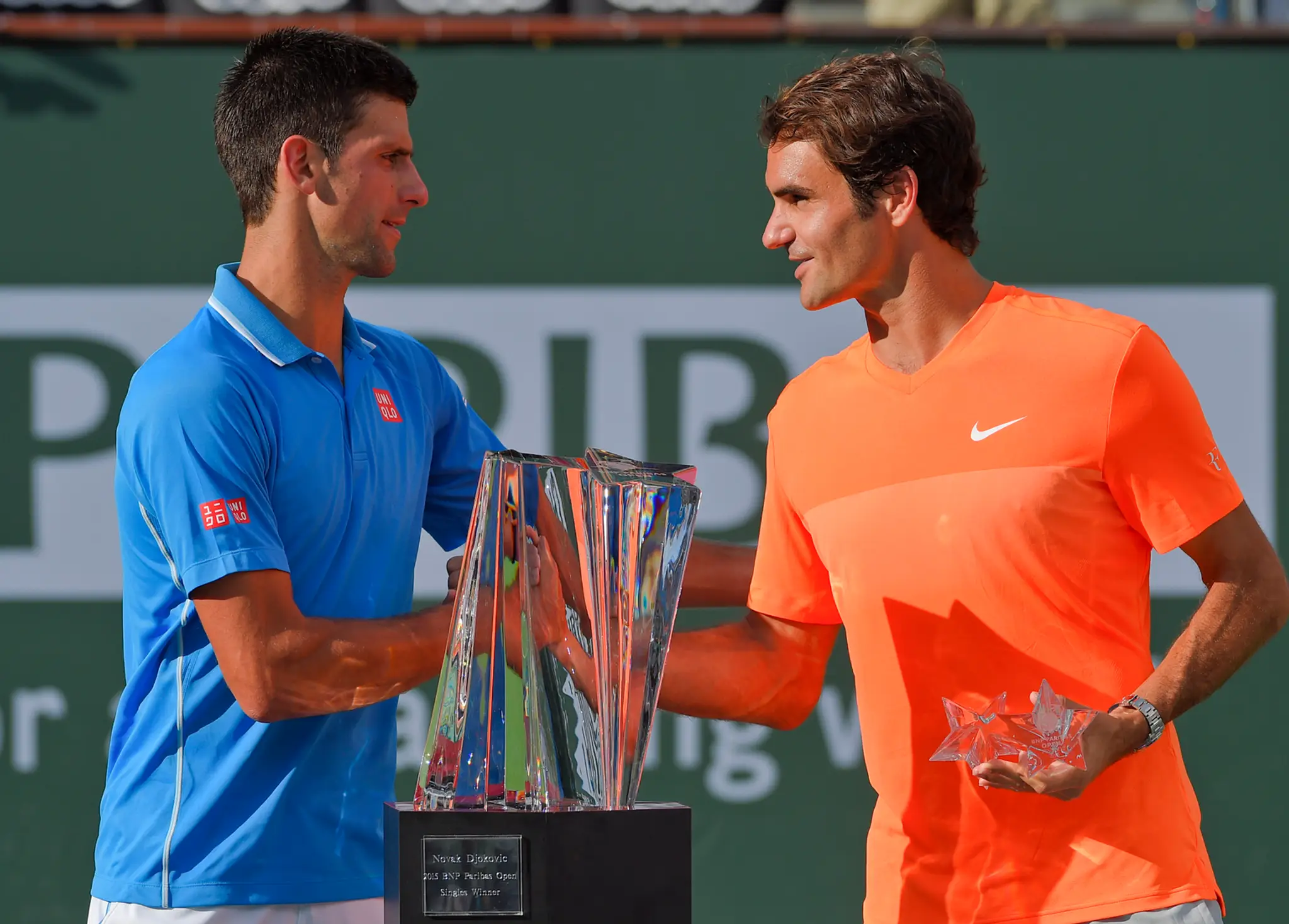 Srbský tenista Novak Djokovič (vľavo) podáva ruku Švajčiarovi Rogerovi Federerovi.