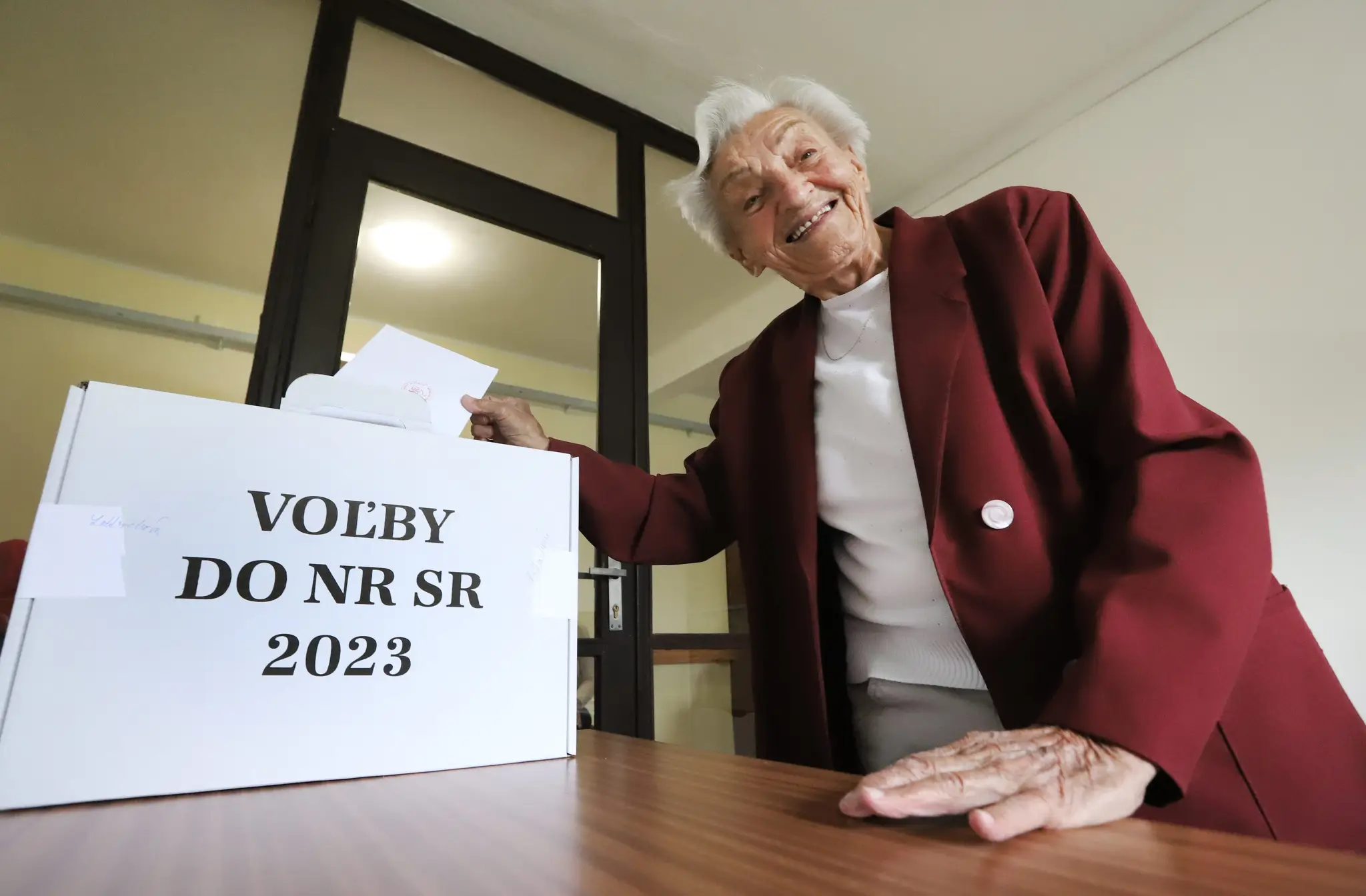 Stodvaročná Mária Longauerová vhadzuje obálku s hlasovacím lístkom do prenosnej volebnej schránky v zariadení pre seniorov Jeseň v Banskej Bystrici.
