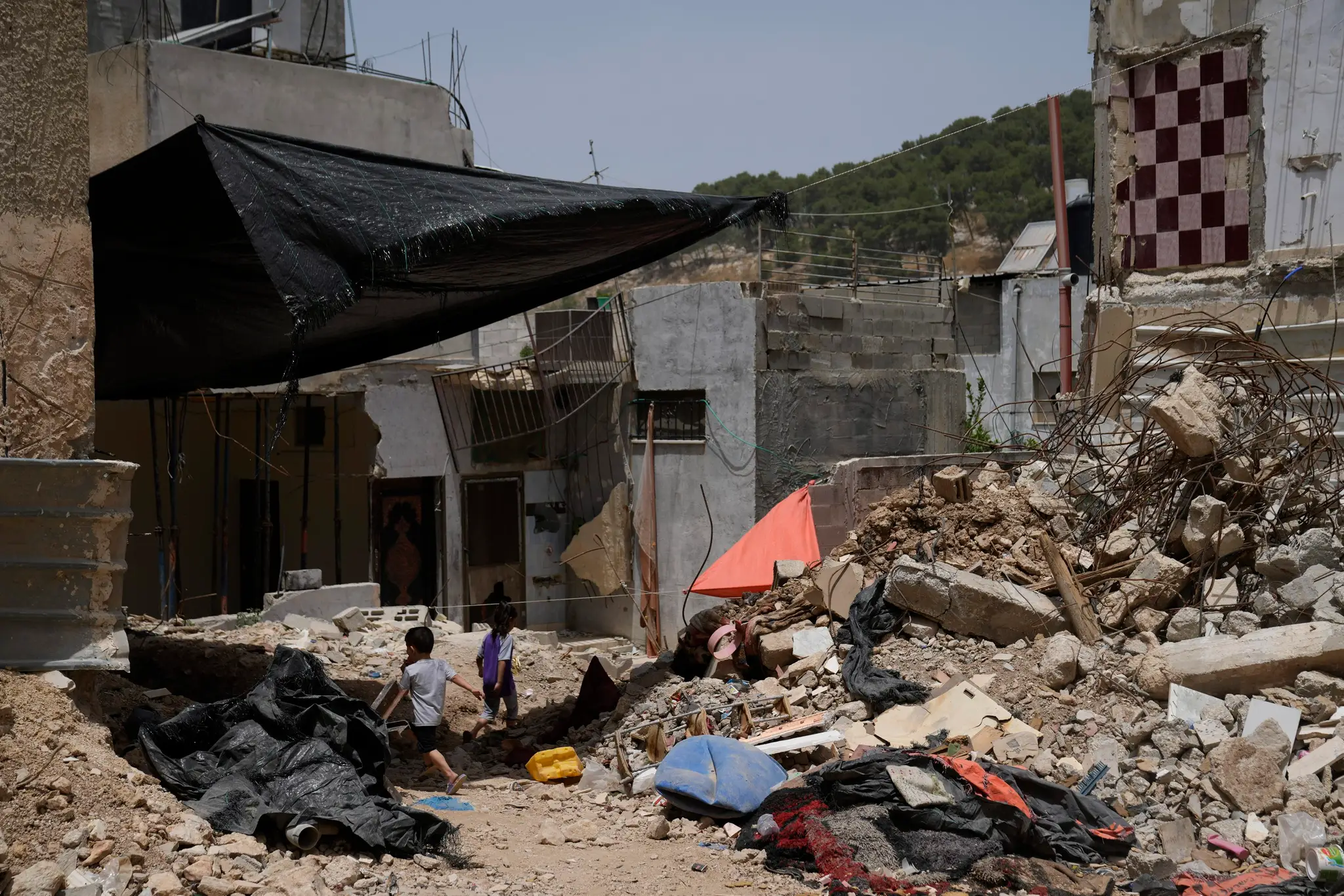 Palestínske deti sa hrajú pri troskách budov, ktoré boli zničené počas operácií izraelskej armády.