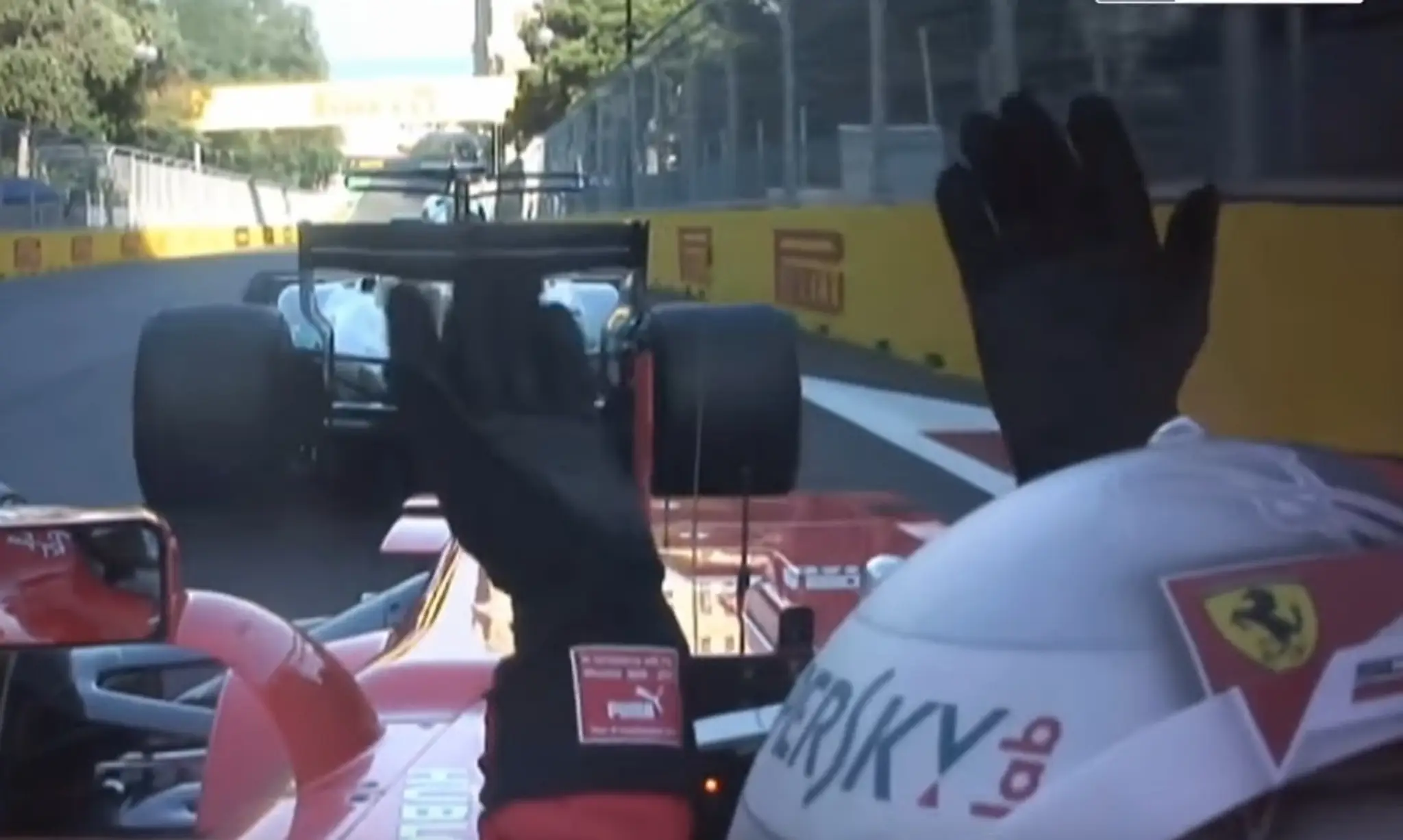 Sebastian Vettel gestikuluje vo svojom monoposte smerom k Lewisovi Hamiltonovi.