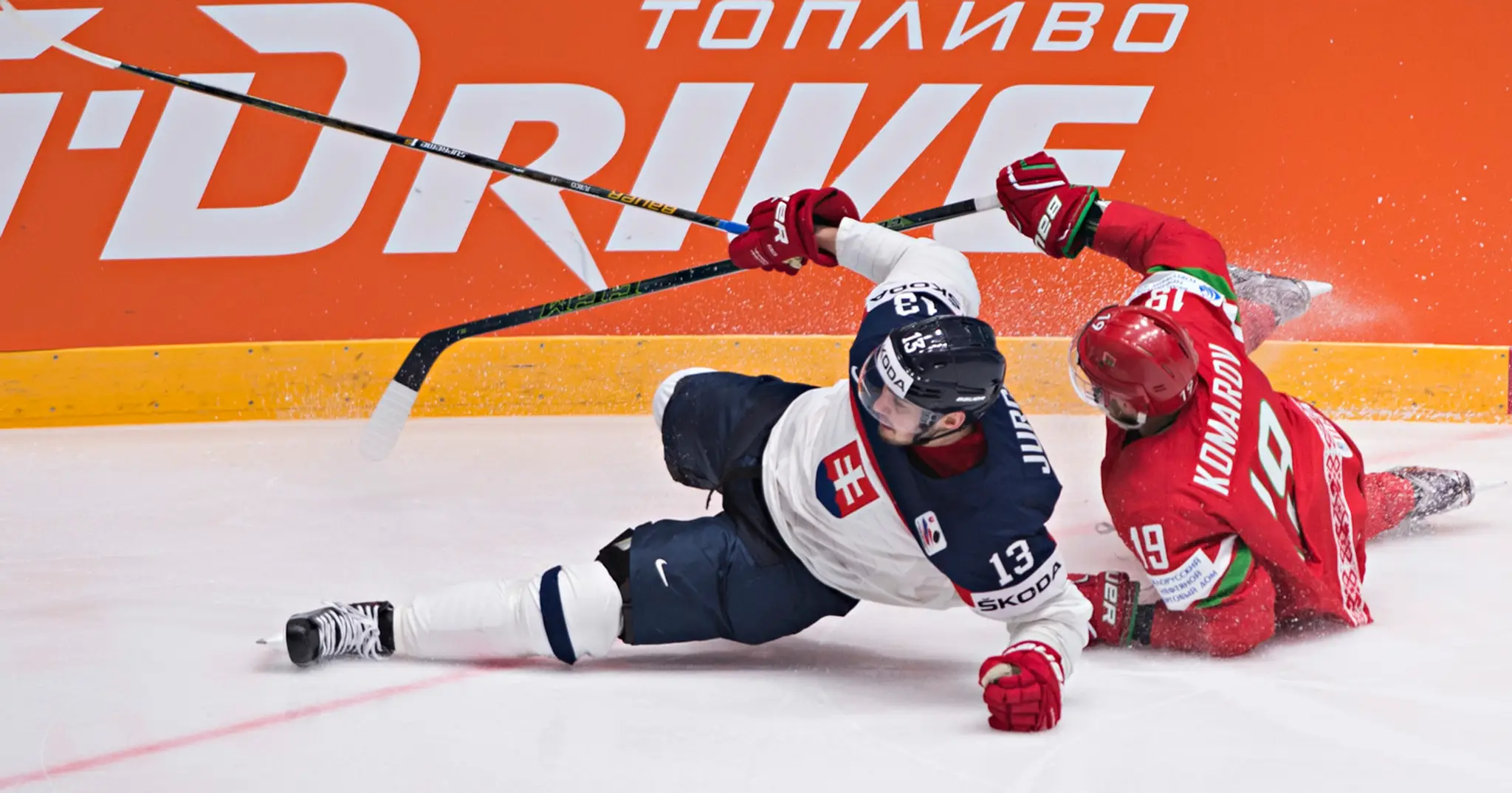 Tomáš Jurčo a Nikita Komarov padajú po súboji v zápase Slovensko - Bielorusko.