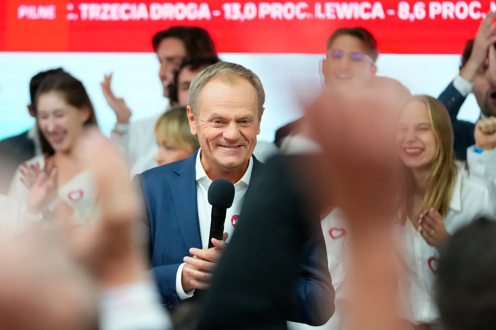 Bývalý poľský premiér a líder opozičnej liberálnej Občianskej koalície (KO) Donald Tusk sa usmieva pred svojimi priaznivcami v sídle strany vo Varšave.