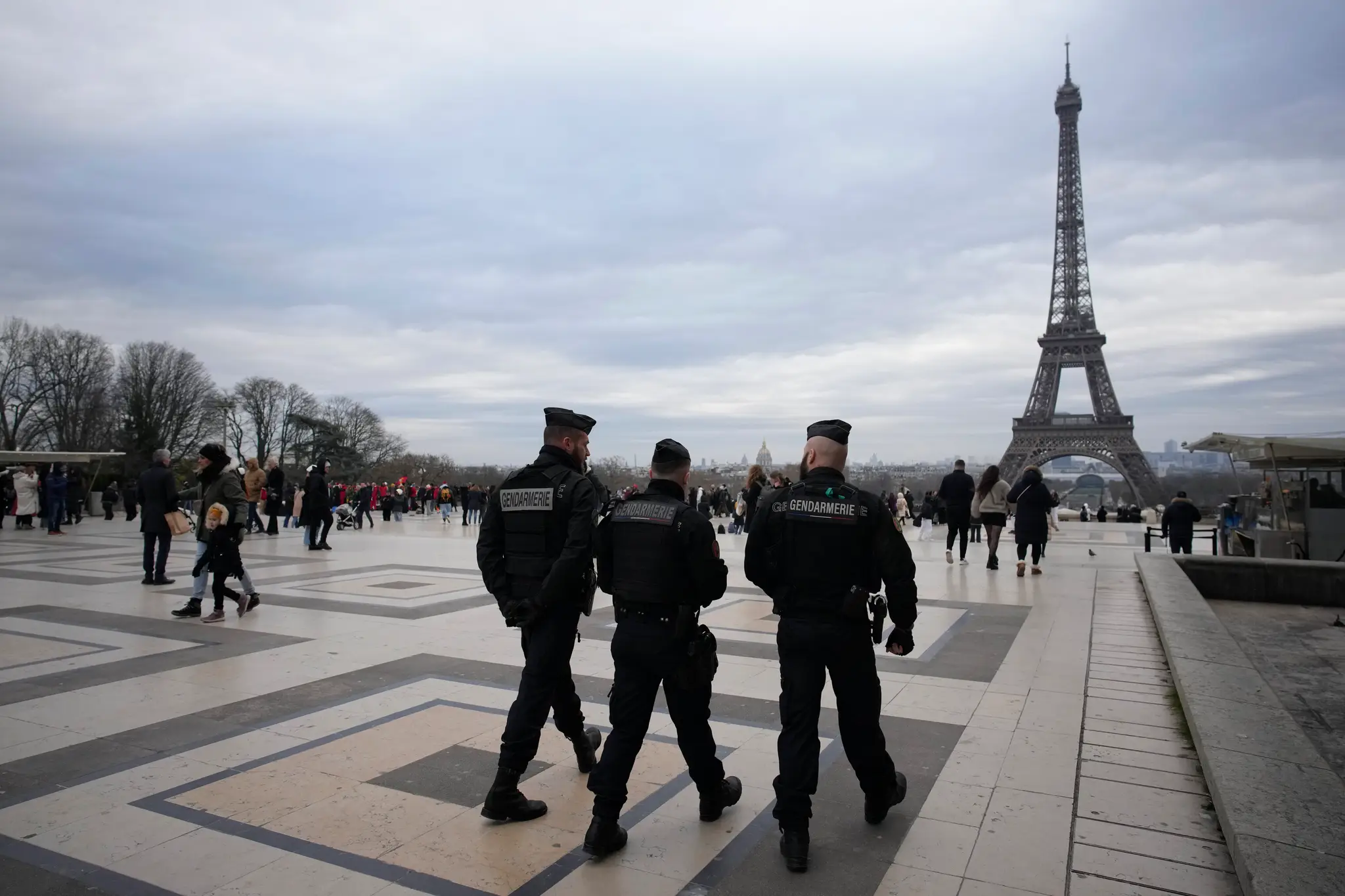 Policajti  hliadkujú neďaleko Eiffelovej veže v Paríži v nedeľu 3. decembra 2023.