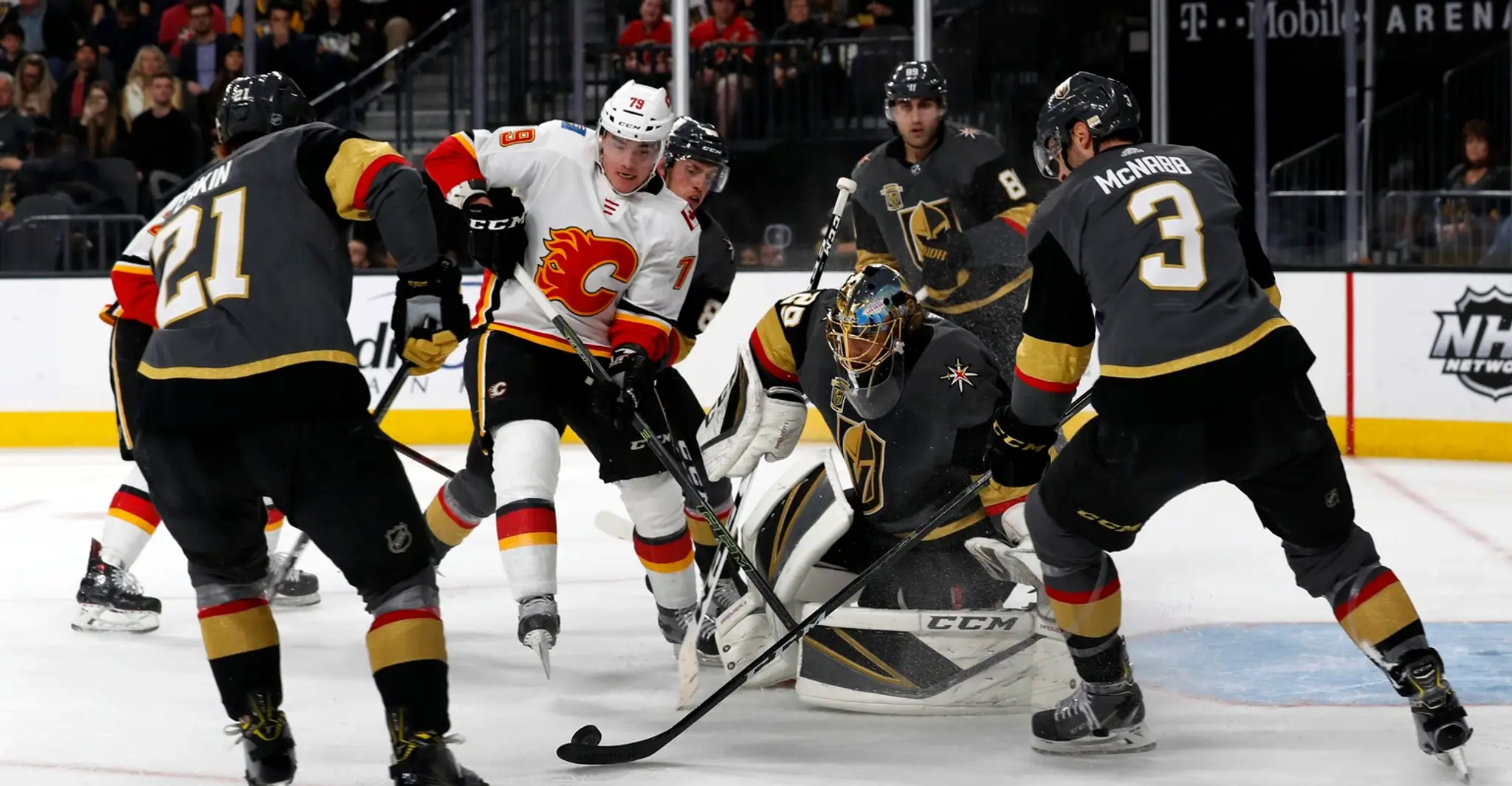 Gólman Las Vegas Marc-Andre Fleury chytá strelu Matthewa Tkachuka z Calgary (v bielom) v dueli NHL.