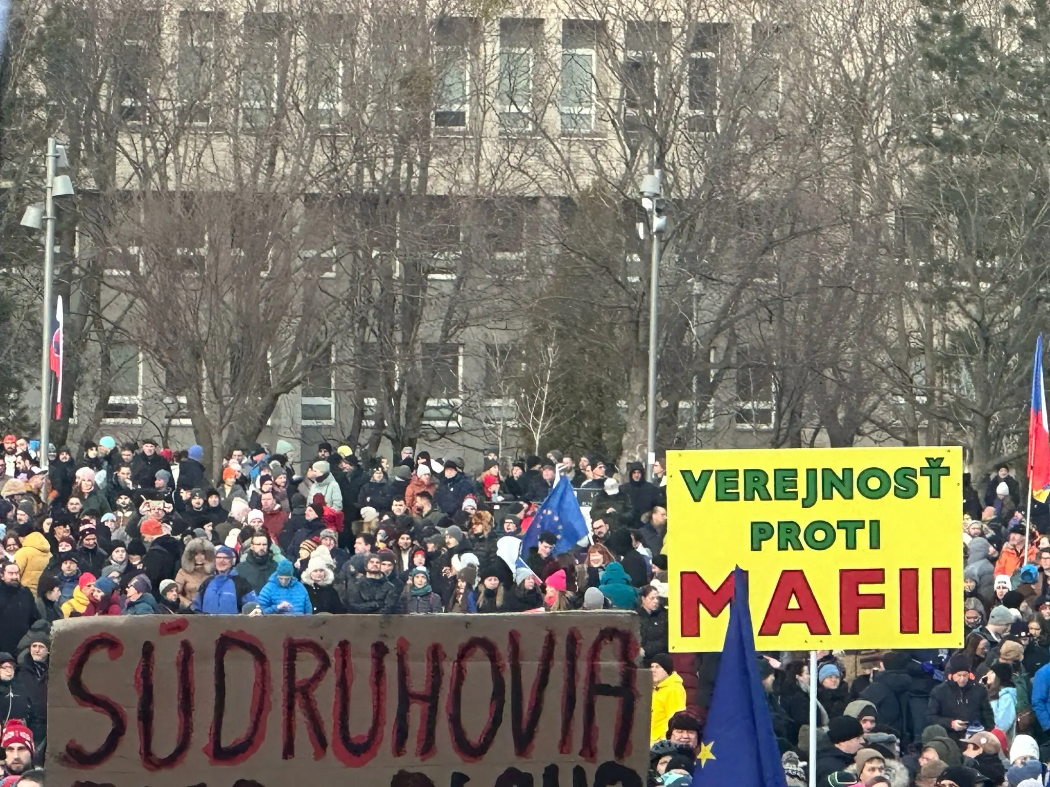 Ľudia s transparentami na spomienkovom zhromaždení