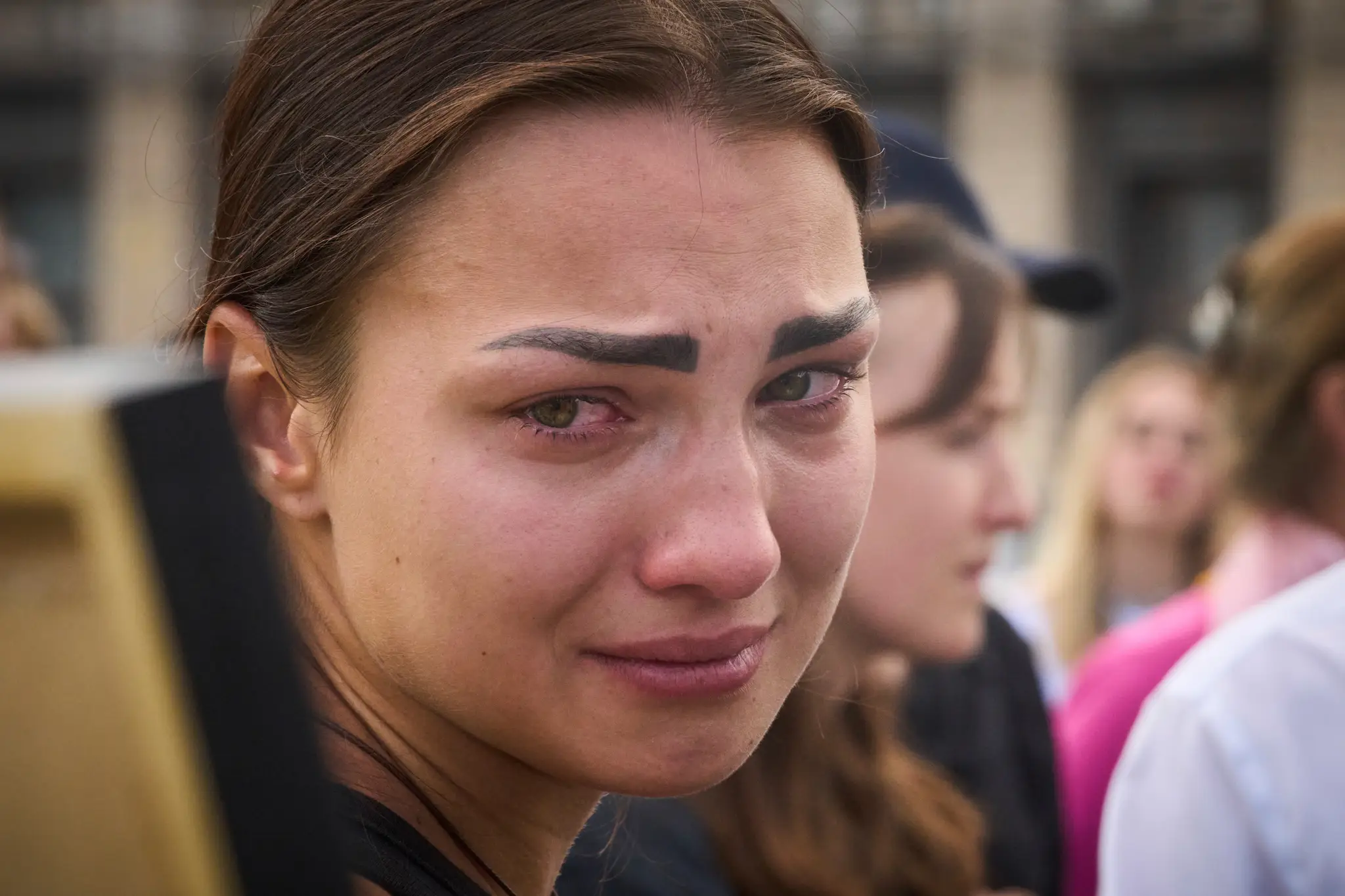 Vojna na Ukrajine. Kolegyňa plače pri pohľade na portrét zabitej novinárky Viktórie Roščinej.