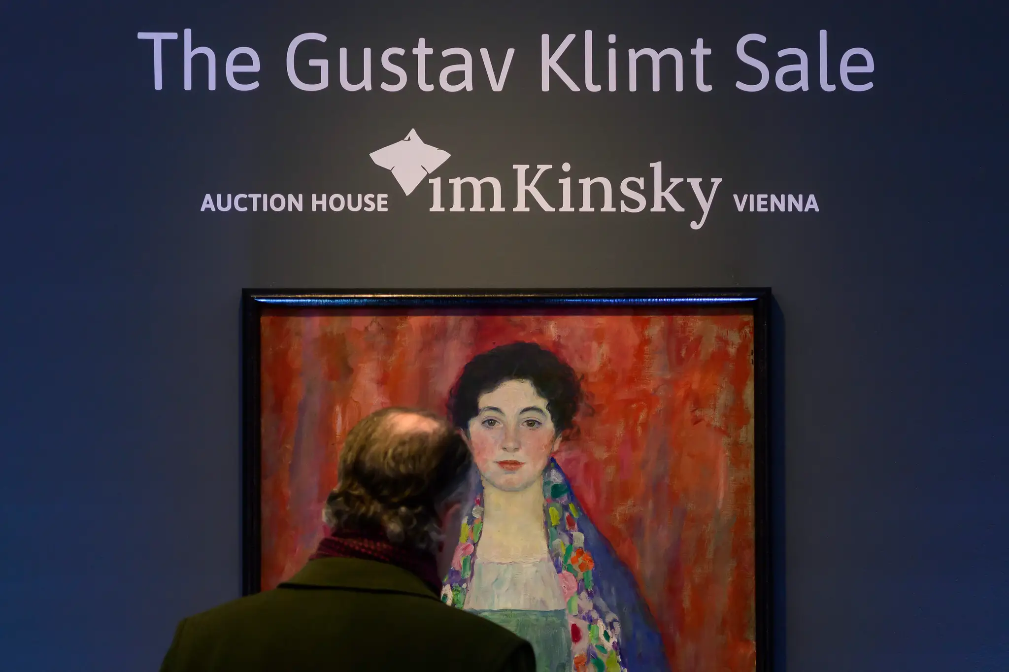 Muž sa pozerá pred aukciou na portrét mladej ženy od Gustava Klimta s názvom Portrét slečny Lieserovej.