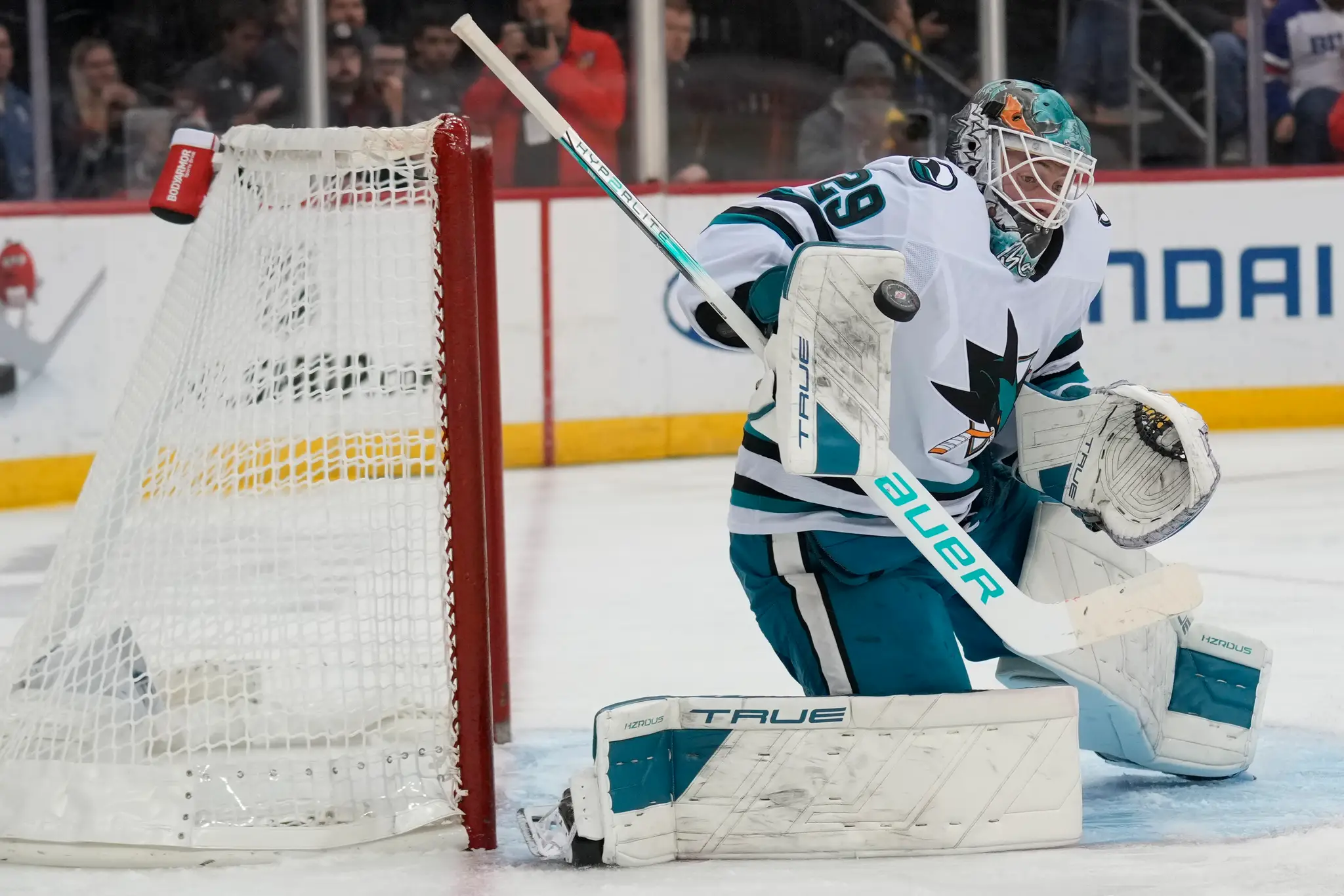 Brankár San Jose Sharks Mackenzie Blackwood vyráža puk v zápase zámorskej NHL New Jersey Devils - San Jose Sharks.