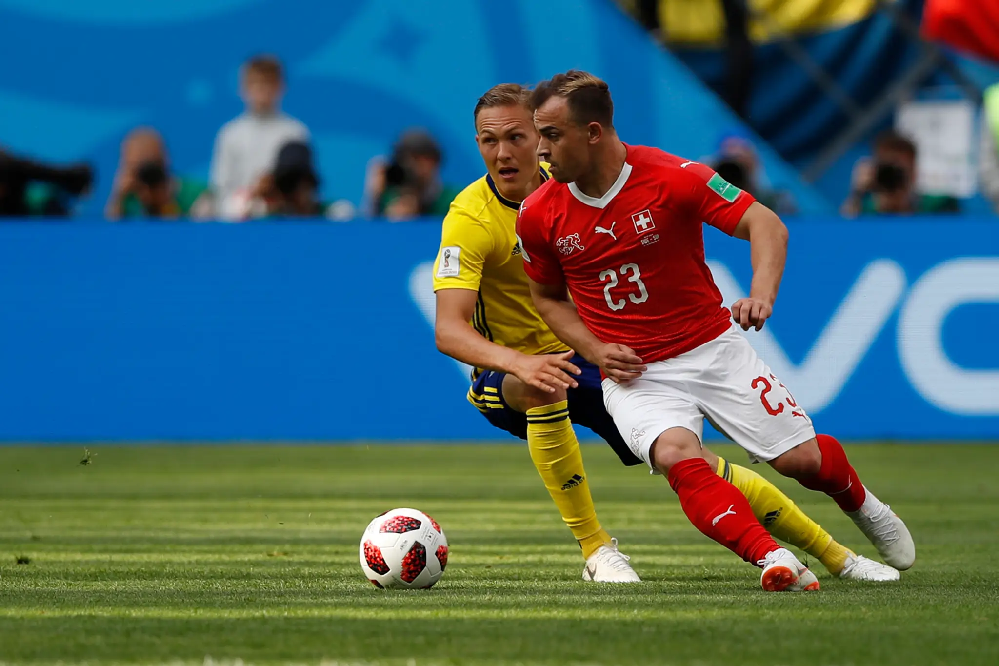 Hráč Švajčiarska Xherdan Shaqiri (vpravo) a hráč Švédska Ludwig Augustinsson v súboji o loptu v zápase osemfinále MS 2018.