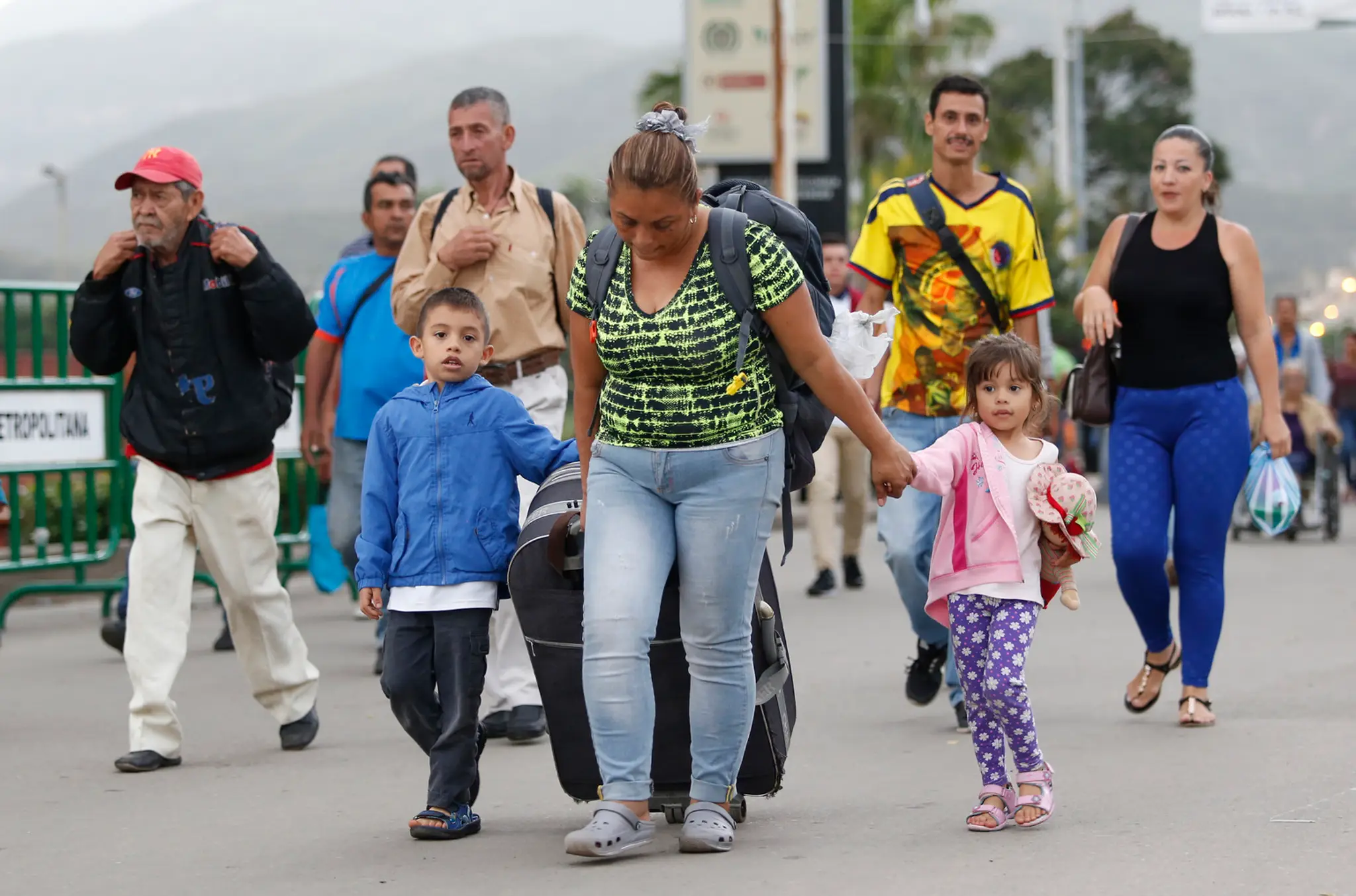 Venezuelská migrantka Yelitza Fuenmayorová s kufrom a deťmi kráča cez most do severokolumbijského mesta Cúcuta.