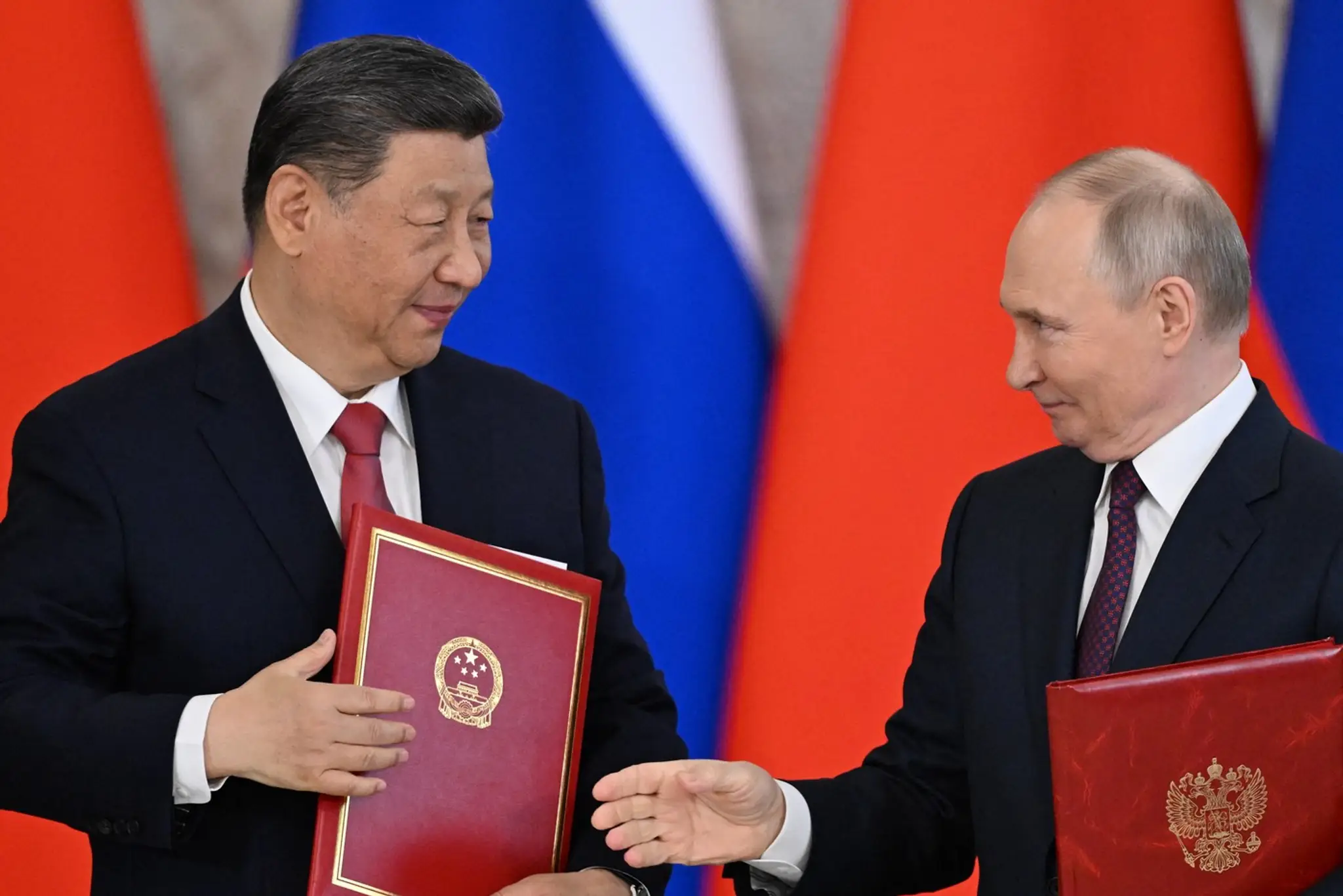 Ruský prezident Vladimir Putin a jeho čínsky aprotivok Si Ťin-pching si vymieňajú dokumenty počas slávnostného podpisu po rokovaniach v Kremli v Moskve.