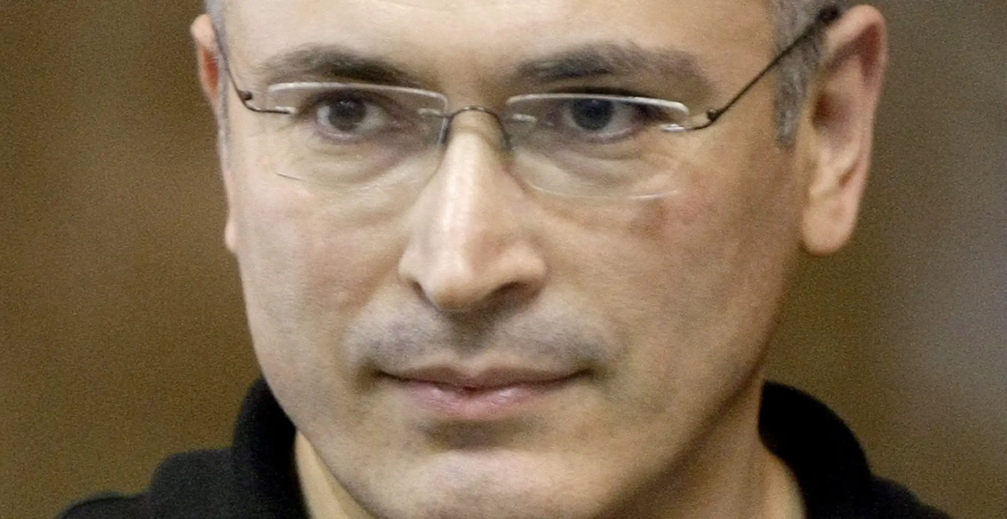 Bývalý šéf Jukosu Michail Chodorkovskij stojí za sklenenou stenou v súdnej sieni v Moskve. (archív 2011)